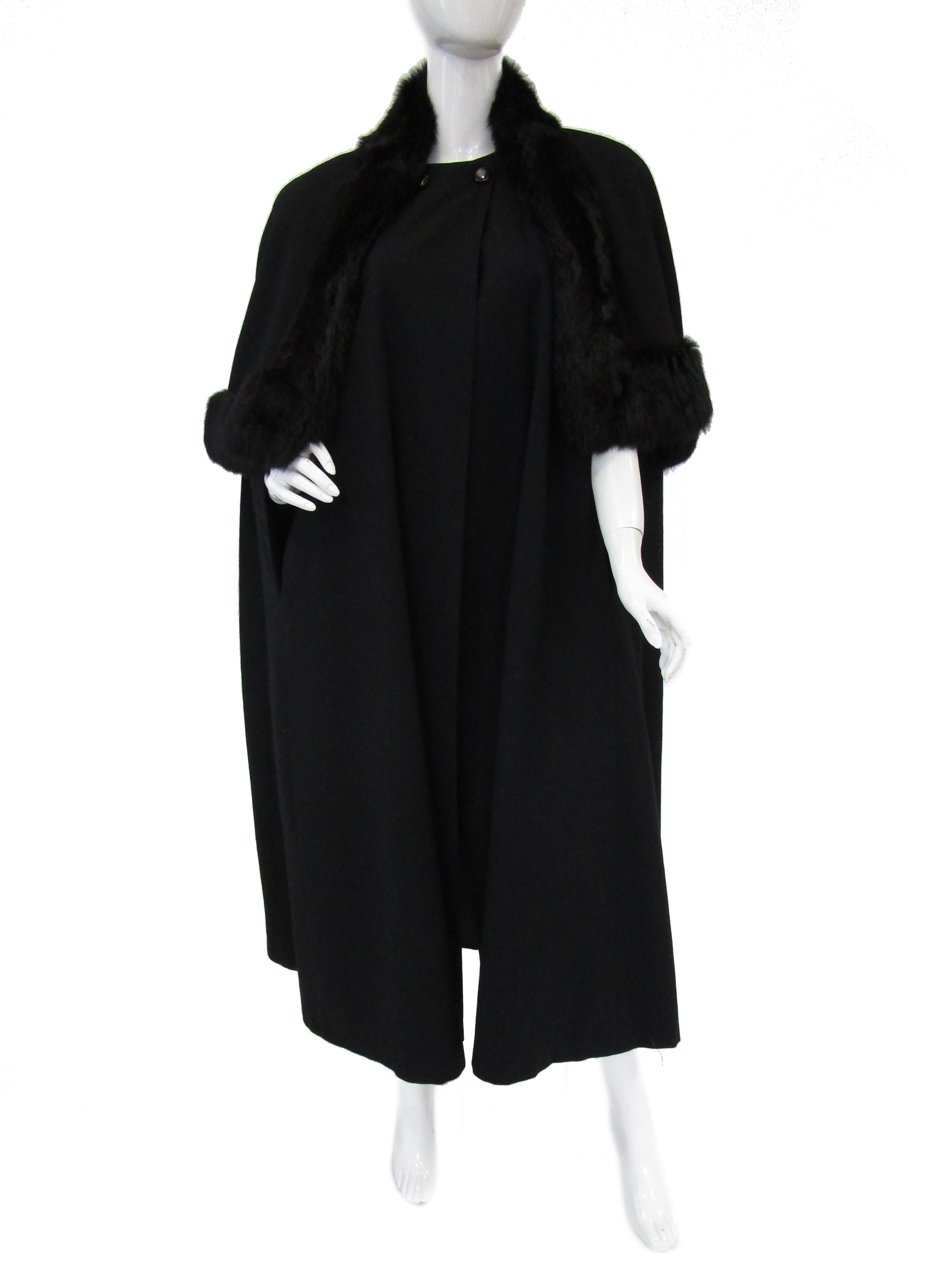 Striking vintage wool cape by George Simonton! The cape is midi length with a bell silhouette and a classic capelet that snaps over top of the cape. The capelet is trimmed in plush, glossy black rabbit fur, that wraps around the neckline, adding an