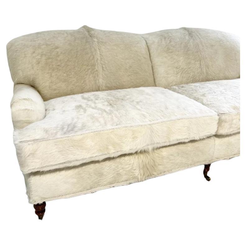 A beautiful, one of a kind sofa. George Smith is well-known for their signature sofas and chairs with English roll arms. We fell in love with this deep seat too. The sofa has been rebuilt and reupholstered in beautiful natural ivory cowhides from
