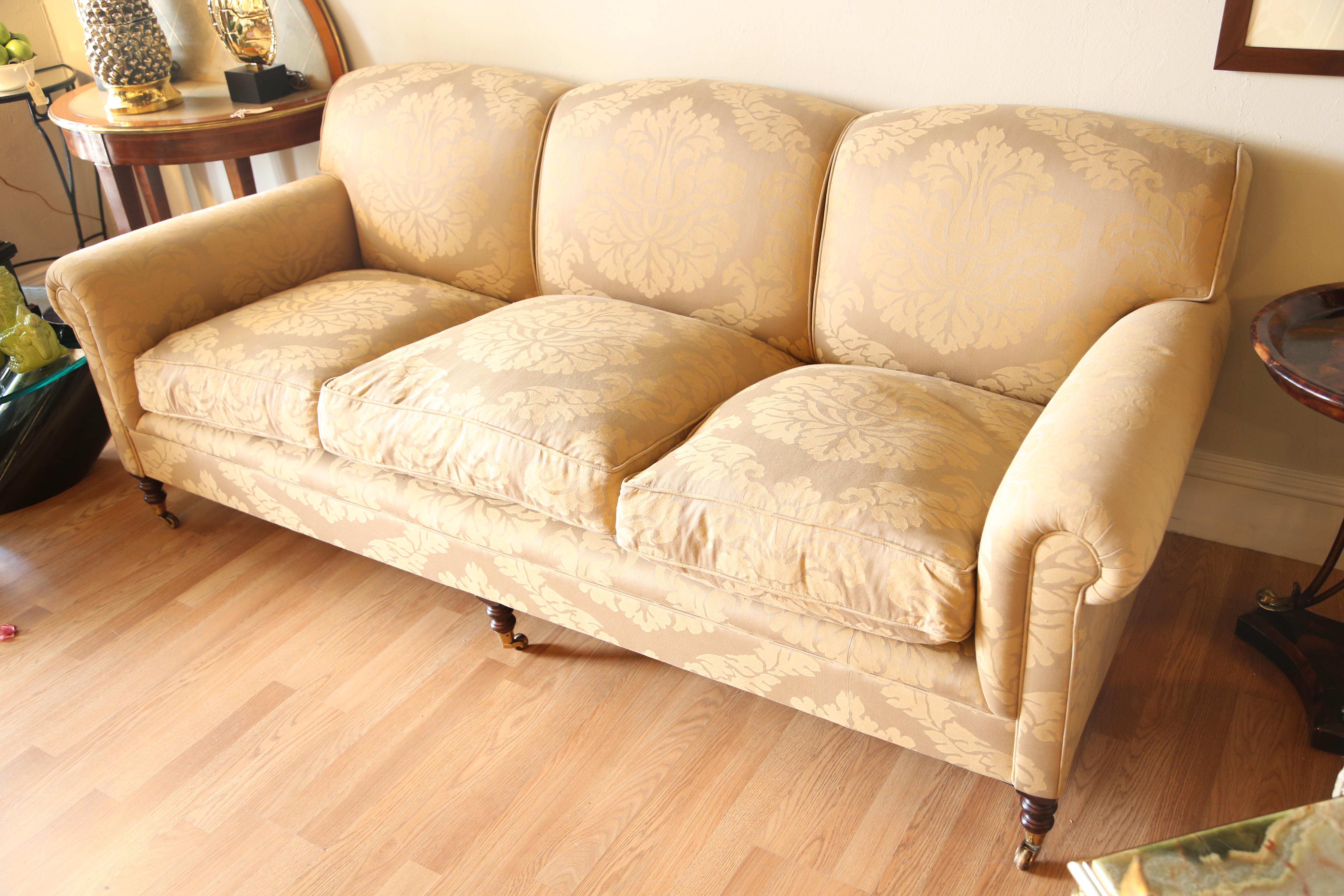 Three-seat George Smith sofa with tight back and three down filled seat cushions. Covered in a gold/green damask fabric.