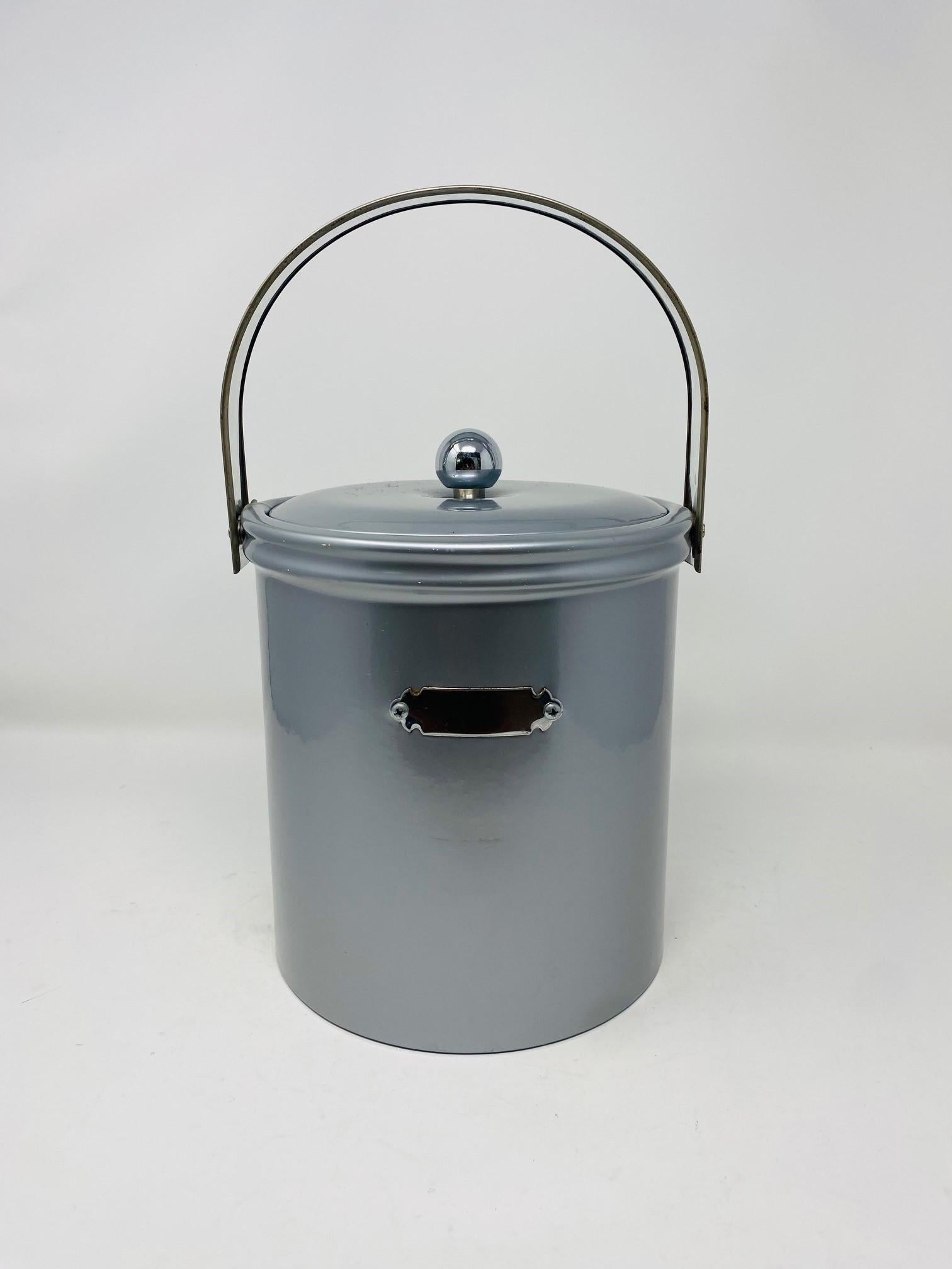 Beautiful vintage ice bucket by Georges Briard.  This piece is finished in a monochrome silver tone with a chrome covered handle that adds a current and distinct look.  The ice bucket includes a statement silver plaque that can be used for