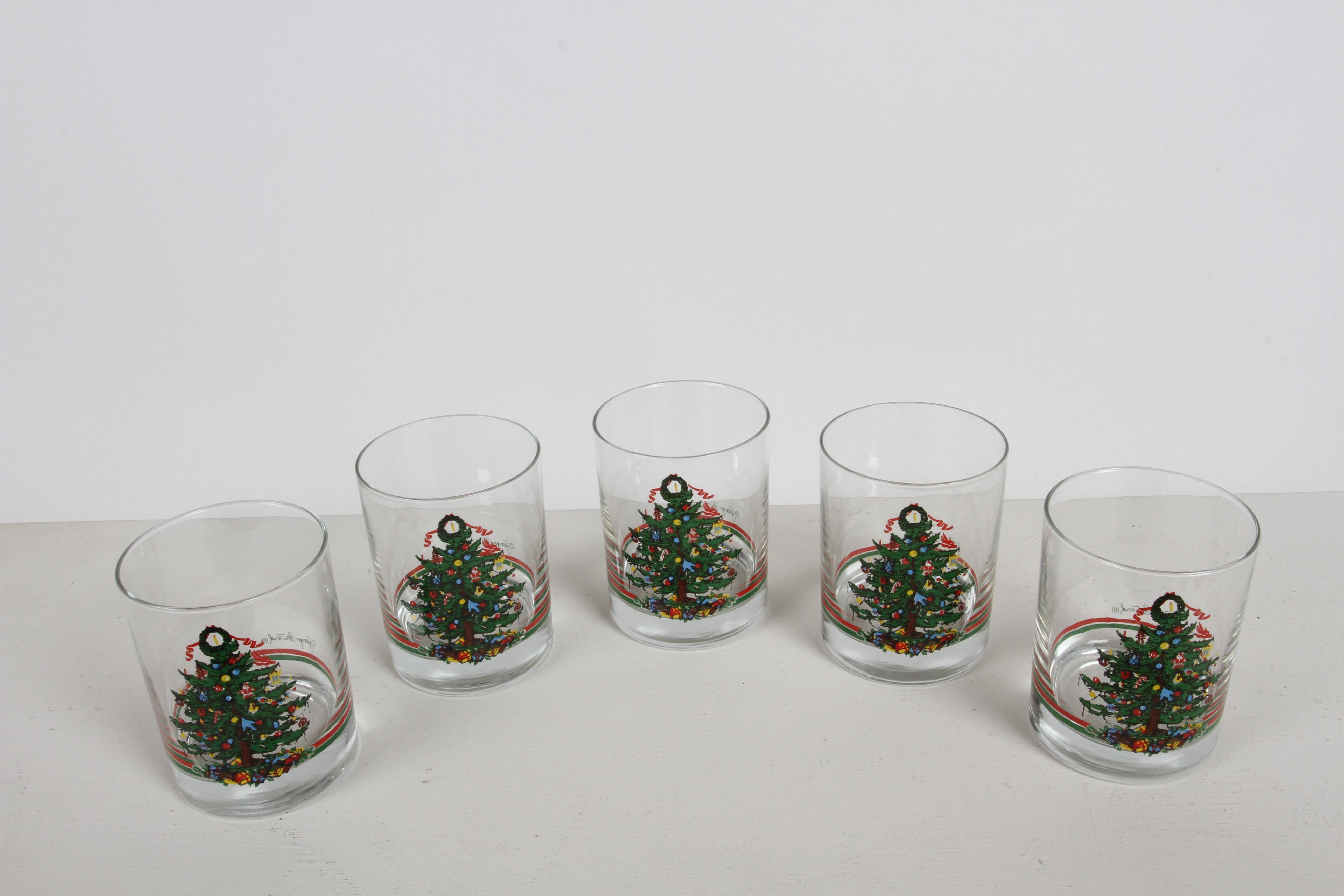 Vintage 1980s Christmas / Holiday theme barware glasses by Georges Briard and retailed by Neiman Marcus. Set of 5 rocks, old fashion or low balls glasses. X-mas trees trimmed with ornaments, like ginger bread man and candy canes with presents under