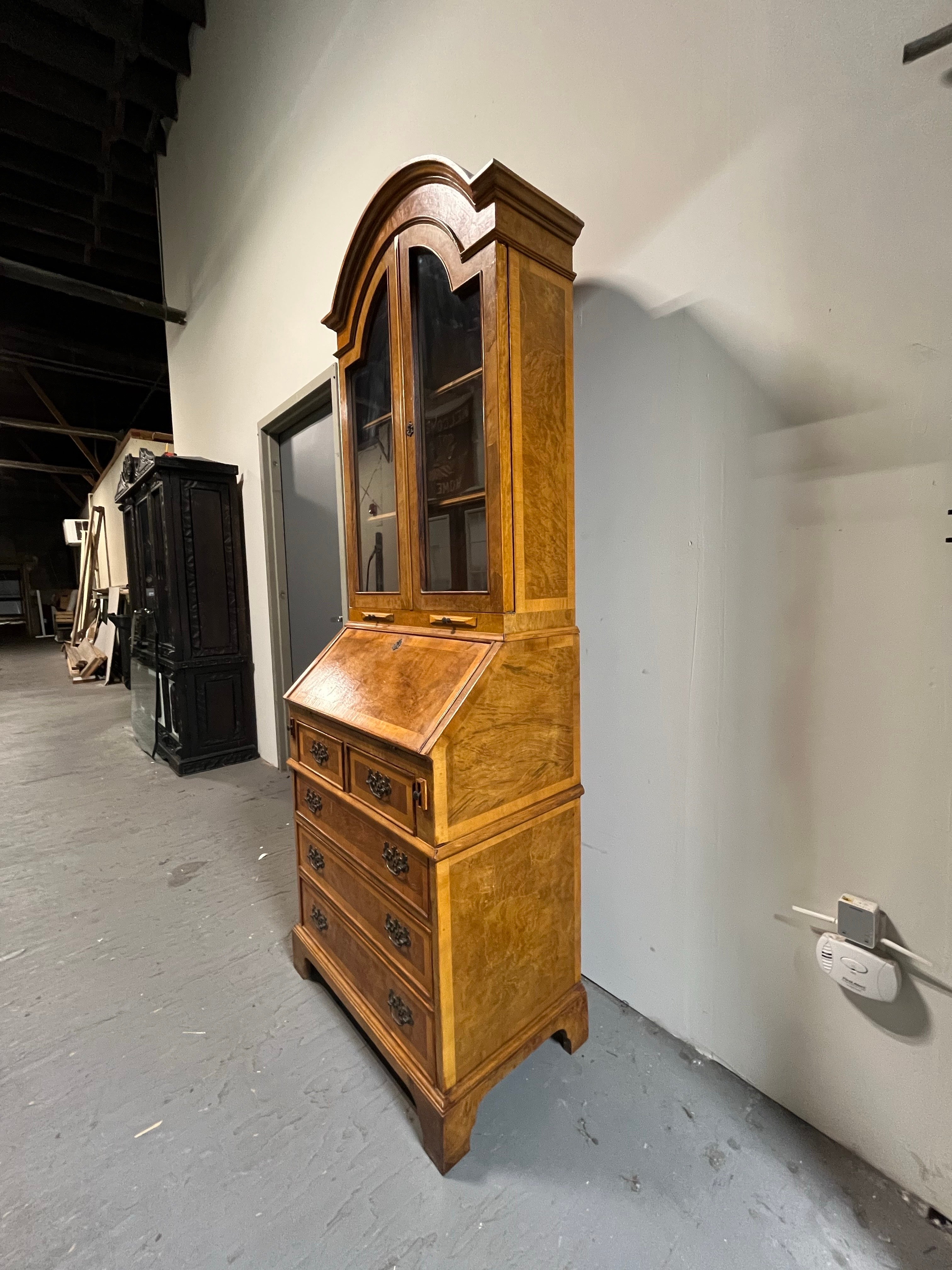 Beautiful Georgian drop front secretary. Made for Bibi Furniture, Italy. appointed burled fruitwood with brass accent pulls. Ample storage with bottom case drawers, double door upper trimmed with cording and 2 shelves. Interior desk offers nooks and