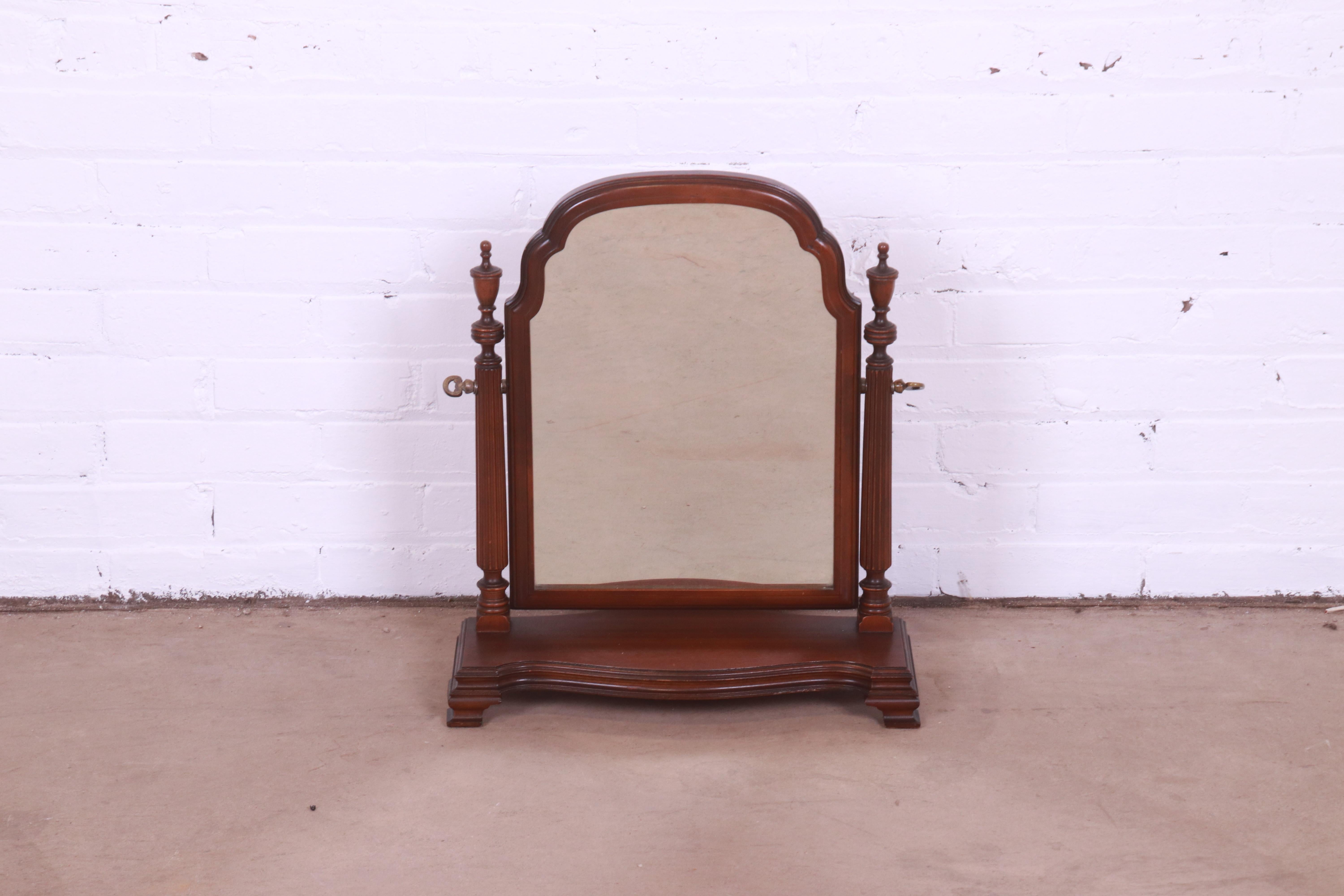 A gorgeous Georgian style dresser top vanity swing mirror

USA, mid-20th century

Carved mahogany, with brass hardware.

Measures: 18
