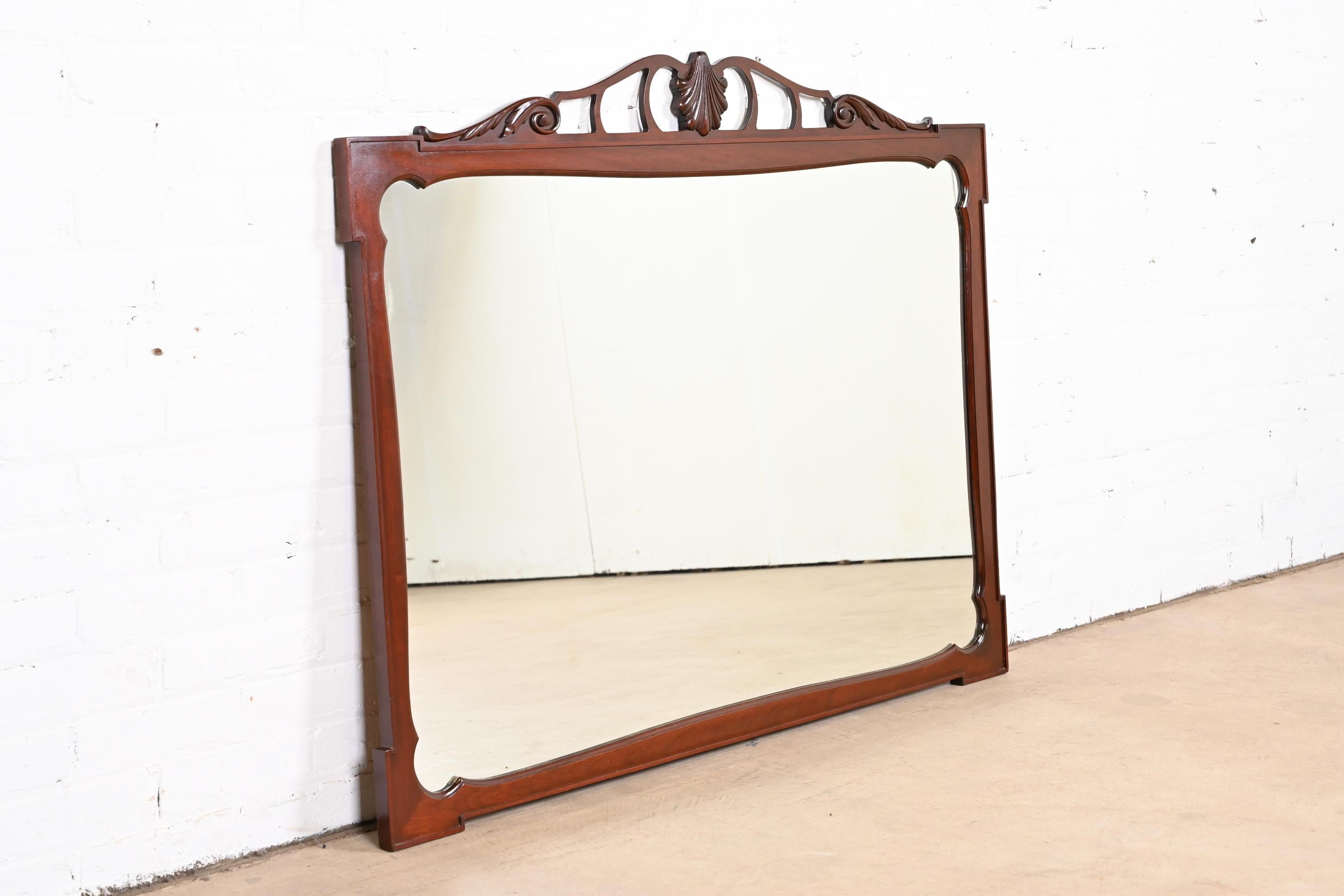 Un elegante espejo de pared tradicional de estilo georgiano con marco de caoba tallada

EE.UU., mediados del siglo XX

Medidas: 47,25
