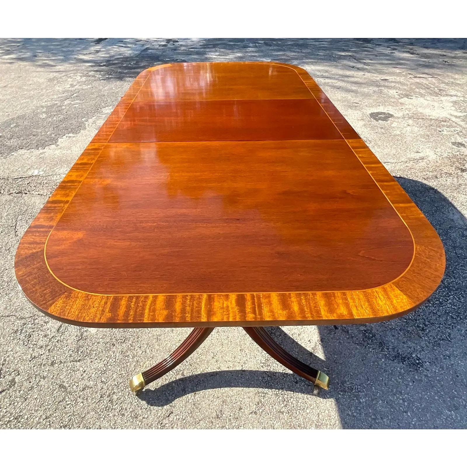 A fabulous vintage Georgian Duncan Phyfe dining table. Made by the iconic Councill furniture group. Beautiful banded mahogany with a double classic pedestal. Acquired from a Palm Beach estate.