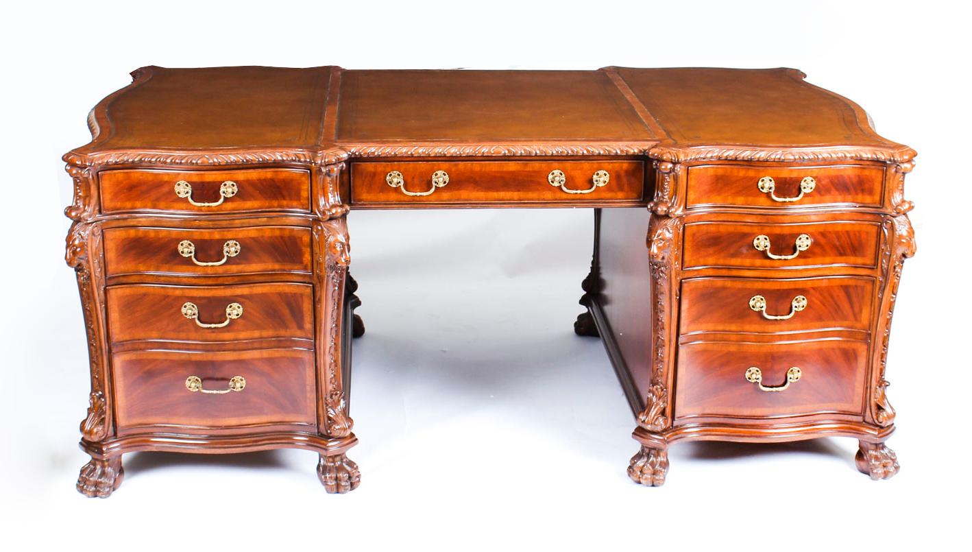 This magnificent flame Georgian Revival mahogany lion's head partners desk dates from the second half of the 20th century and demonstrates the highest standards of the cabinet maker’s craft. 

The desk is finished all round so it is free standing,