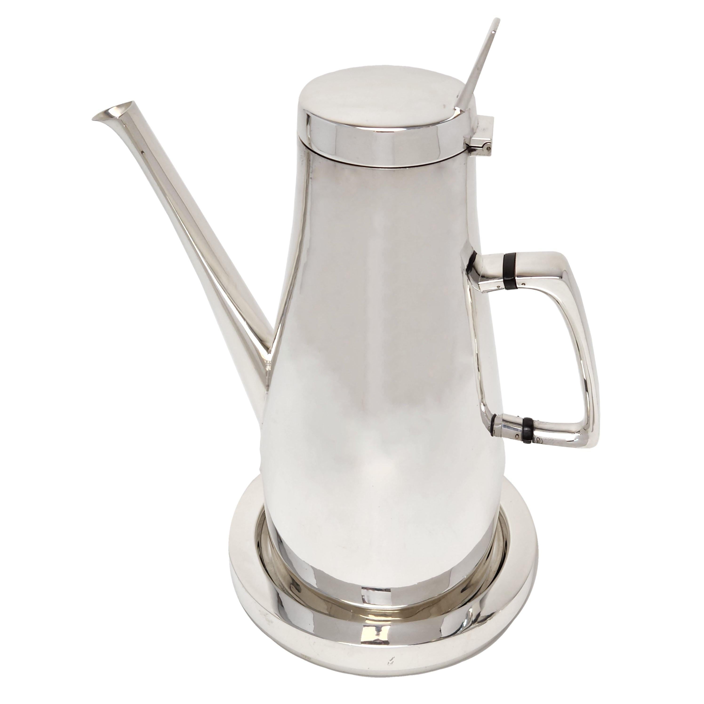 An impressive sterling silver coffee pot made by Gerald Benney. This magnificent Coffee Post if of a large size and has an elegant polished form. It rests on a round Silver Stand. 

Made in London, England in 1965 by Gerald Benney.

Approx.