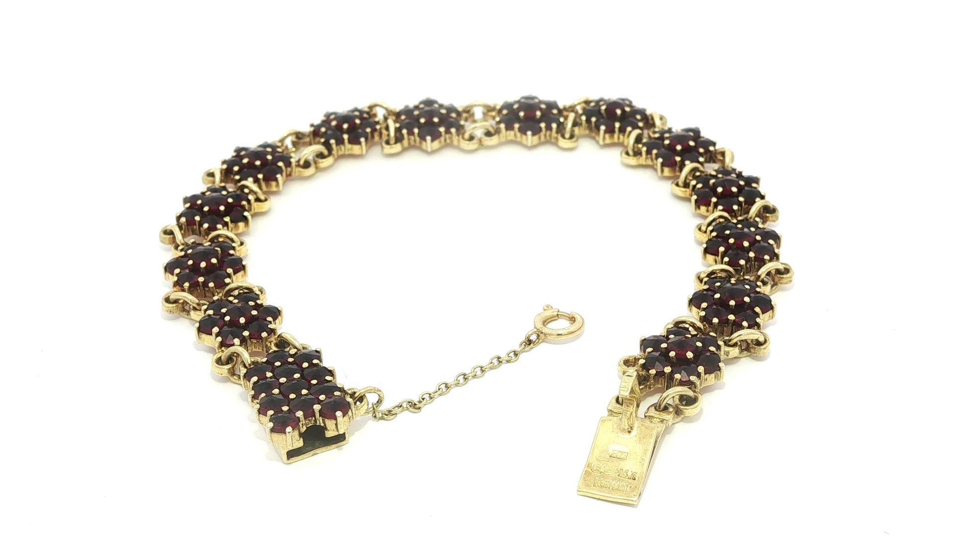 -Stein(e)-
Zahlreiche natürliche, echte böhmische Granate - runder Brillantschliff - Zackenfassung - tiefrote Farbe - je 2,7 mm (ca.)

MATERIAL: Massives 14k Gelbgold 
Gewicht: 16,16 Gramm
Art: Cluster Flower Line Link
Länge: Messen Sie 7.0 Zoll