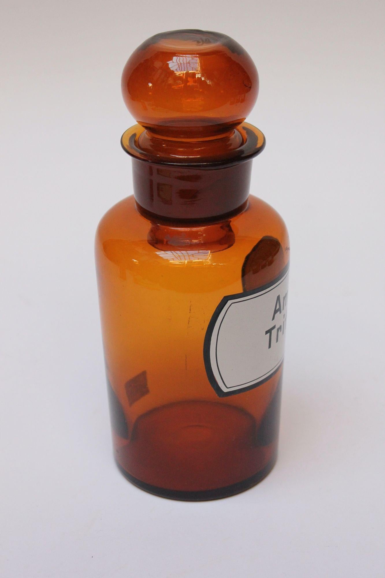 'Amyl. Tritici' (Amylum Tritici) pharmacy bottle/apothecary jar (circa late 1920s/early 1930s, Germany).
Amber glass with orb stopper and enamel label. 