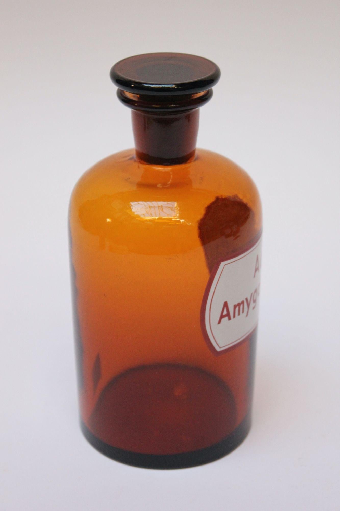 'Aqua Amygdal amar' (Aqua Amygdalae Amarae / Bitter Almond Water) pharmacy bottle/apothecary jar (circa late 1920s/early 1930s, Germany). 
Amber glass with button stopper and enamel label. 
Good, vintage condition with soiling to the bottle's