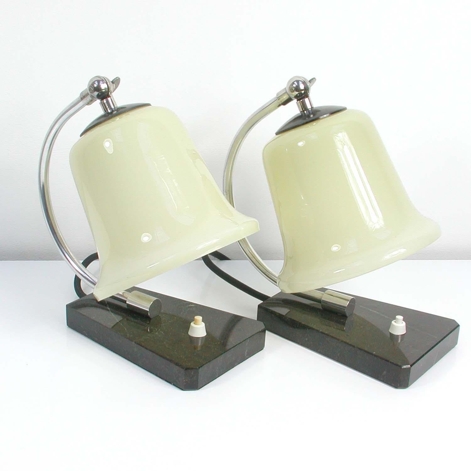 These table lamps were manufactured in Germany during the Bauhaus era in the 1930s. They have got a black marble base and a chrome lamp arm with adjustable opaline glass lamp shades.

Condition is very good with just minor signs of use and some