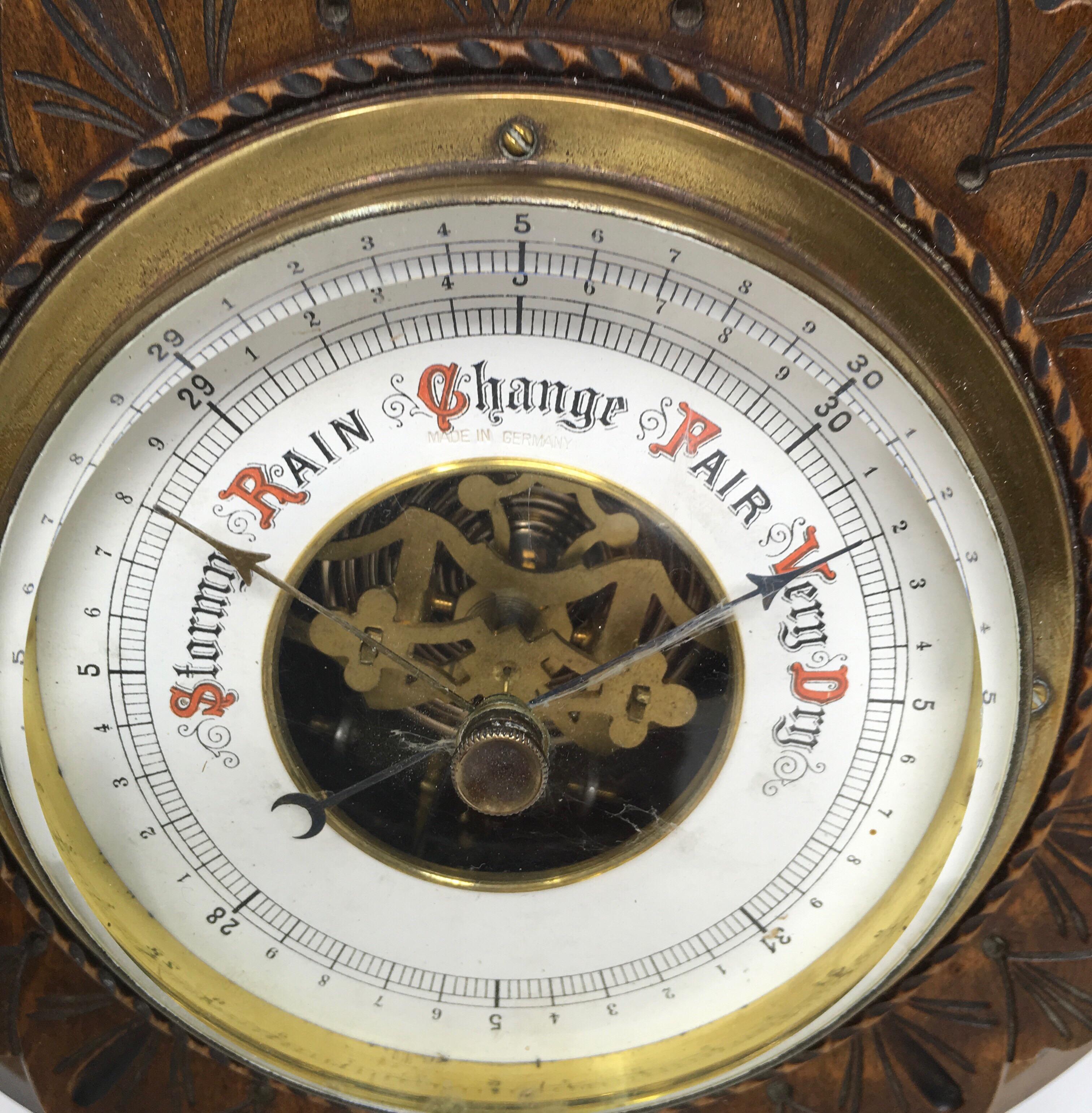 Very nice vintage carved wood barometer with a brass bezel and thick glass beveled edge from Germany. The enamel dial along with the visible movement are in good condition and very decorative.