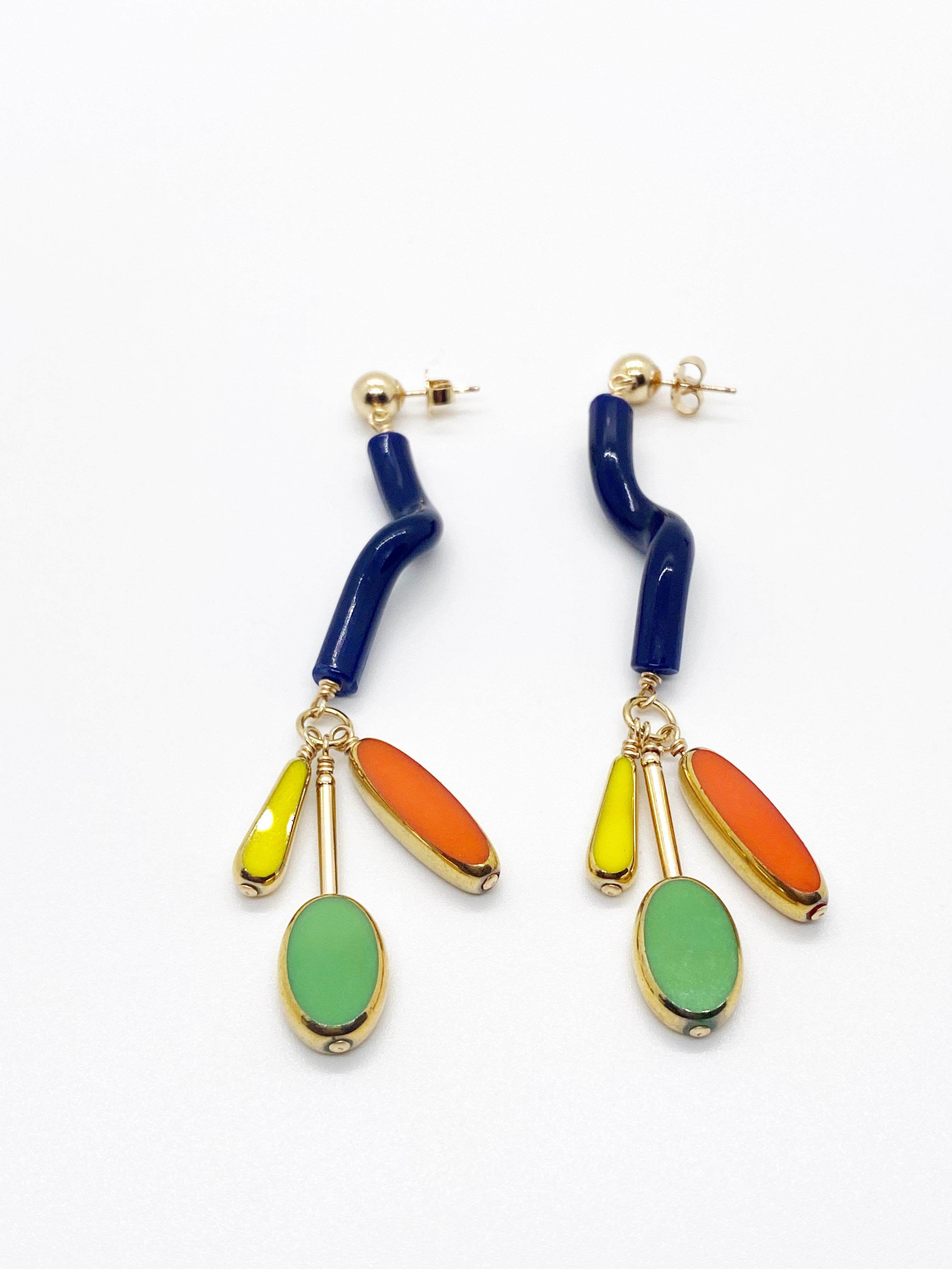 These are such fun earrings. These earrings will sure be a conversation starter. It consist of vintage noodle glass beads with 3 bright vintage glass beads that are edge with 24K gold and finished with 14K gold filled stud.

The vintage German beads