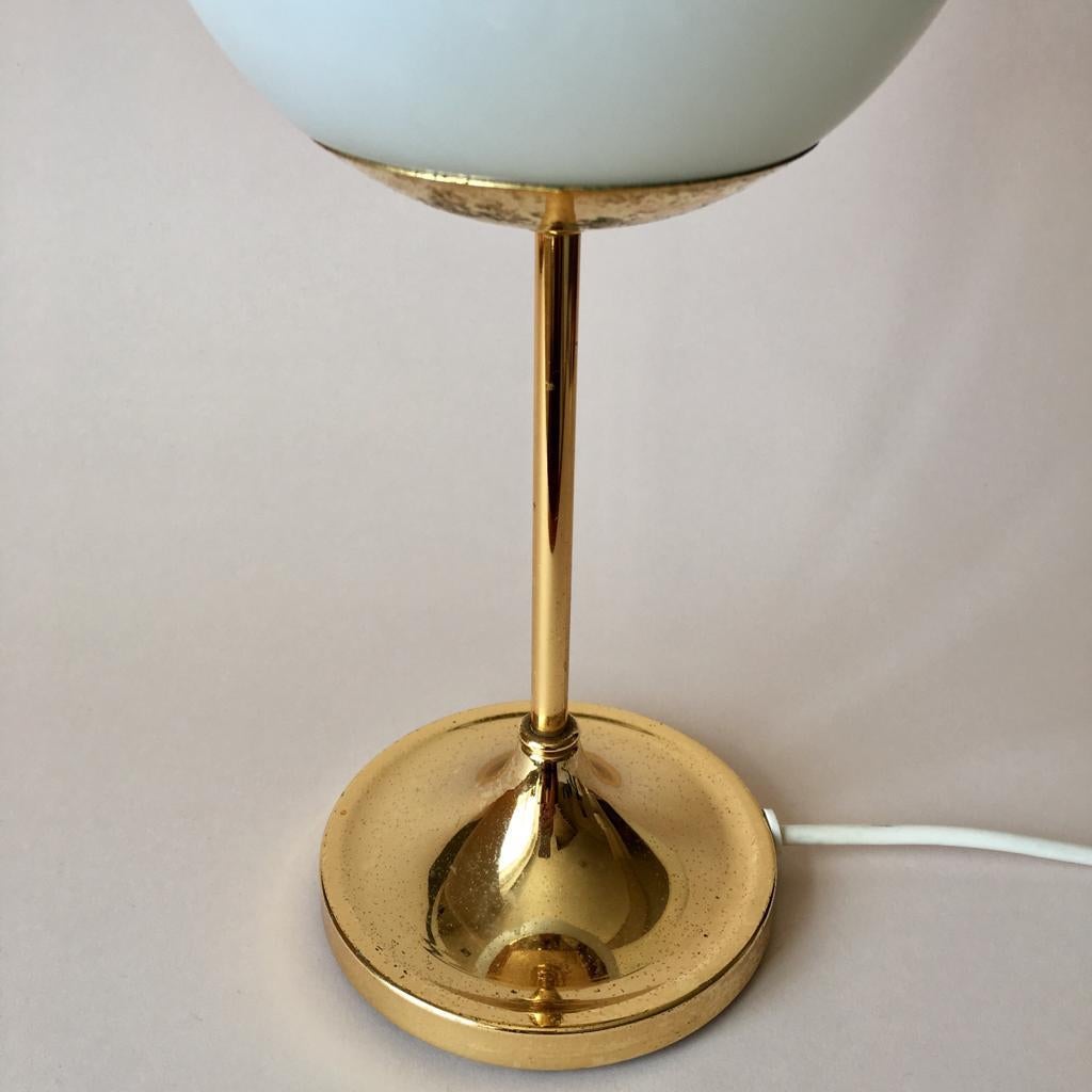 Gilt brass table lamp base with heavy iron part in the bottom, opaline glass ball shade. Very soft light. Features nice patine.

H 30.5 cm
D(shade) 12 cm
D(base) 10.5 cm