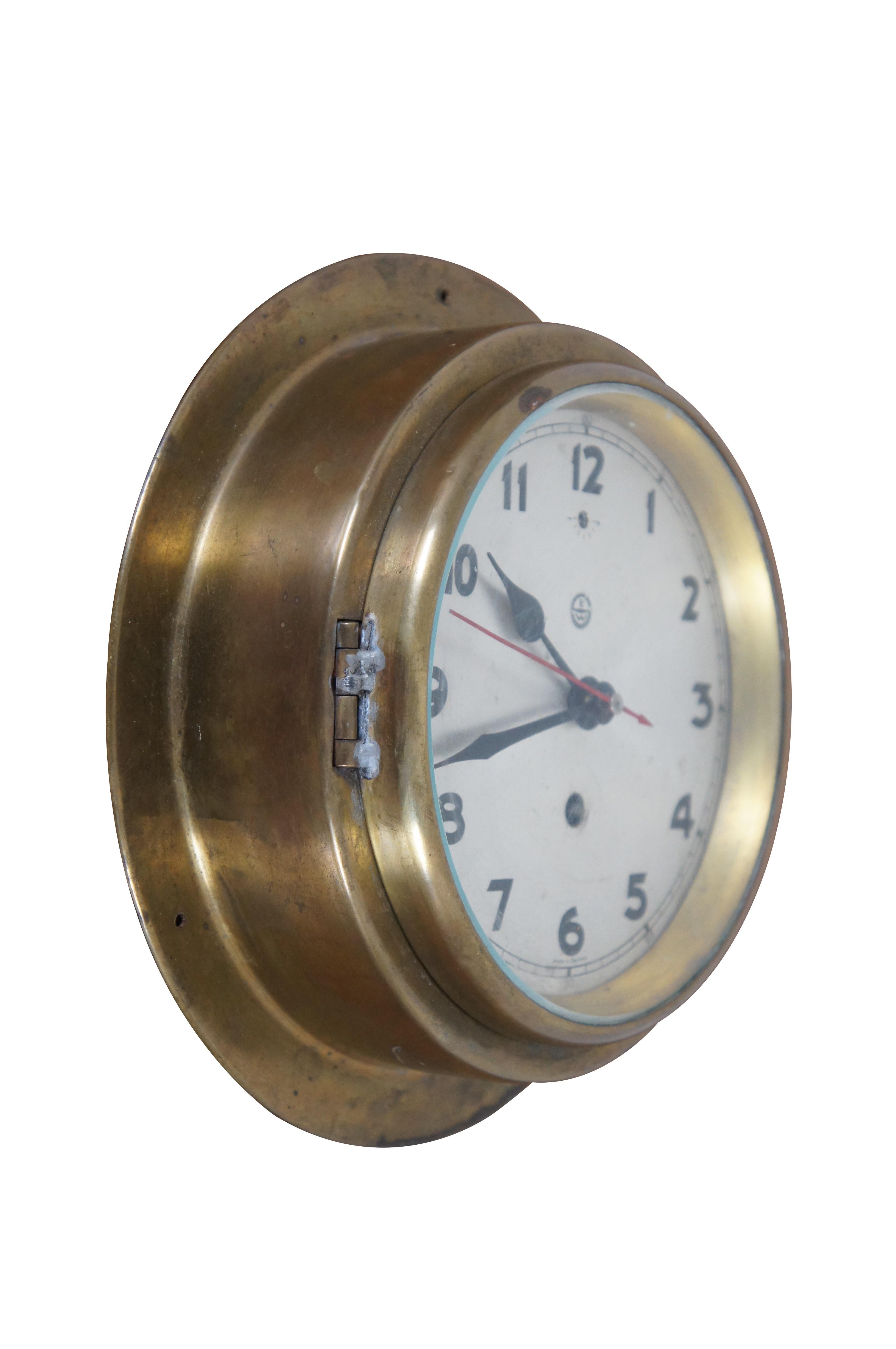 Mid 20th century key wound port hole clock.  Features a brass frame with metal dial and glass window.  Hangs via 3 screw holes at the base.  Marked along the face EW

A porthole, sometimes called bull's-eye window or bull's-eye, is a generally