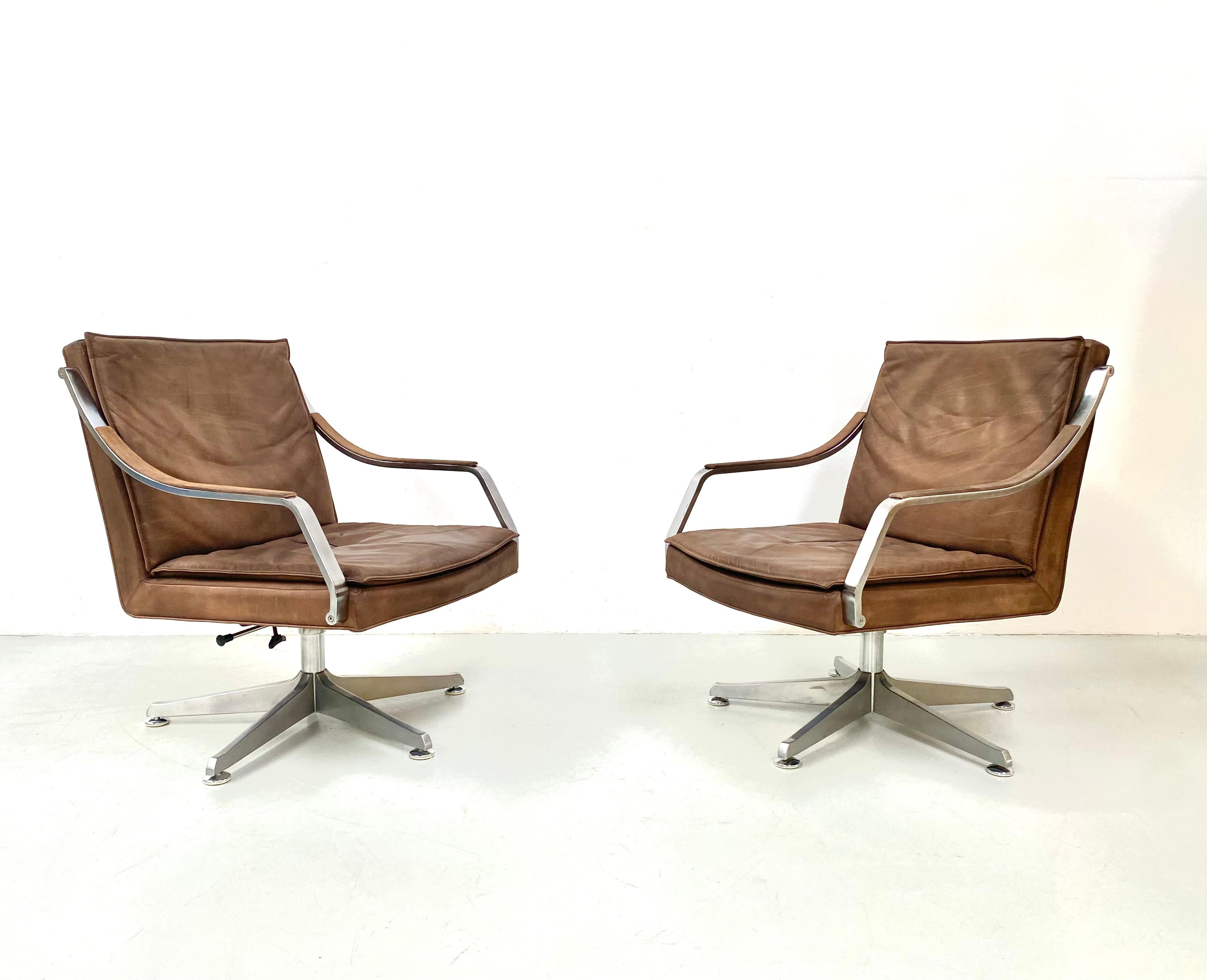 This set of 2 brown leather conference chairs from the art collection, designed by Rudolf B. Glatzel for Dreipunkt and Knoll in the 80s, is in very good condition. The dark brown leather shows only slight signs of wear, the stainless steel feet are