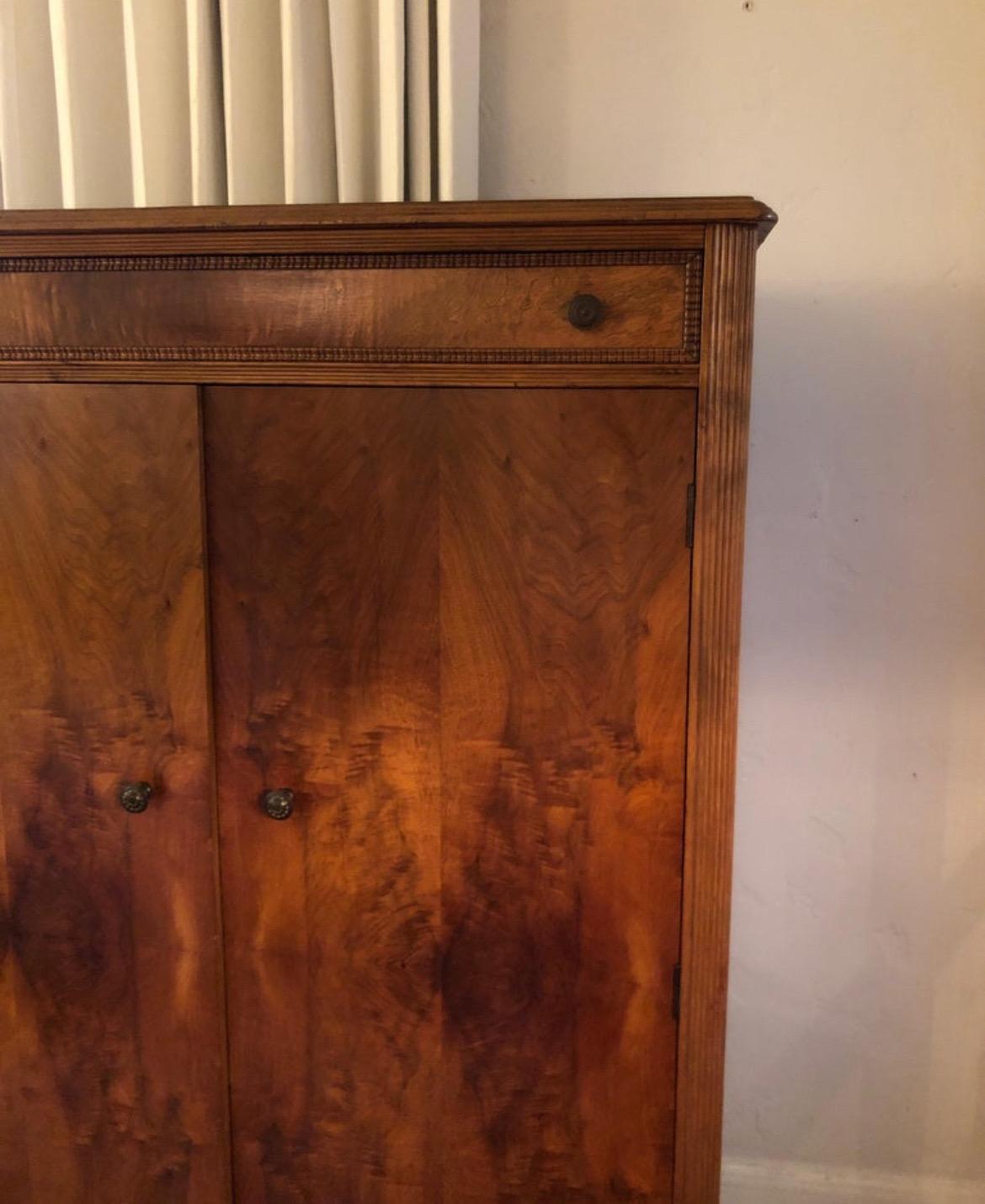 19th century German style small Bedermeier armoire/wardrobe with burl wood cherry.
One long drawer at the top. Interior has shaves and three drawers.
Sits on top of carved legs with castors.
A fine example of clean lines with minimal ornamentation