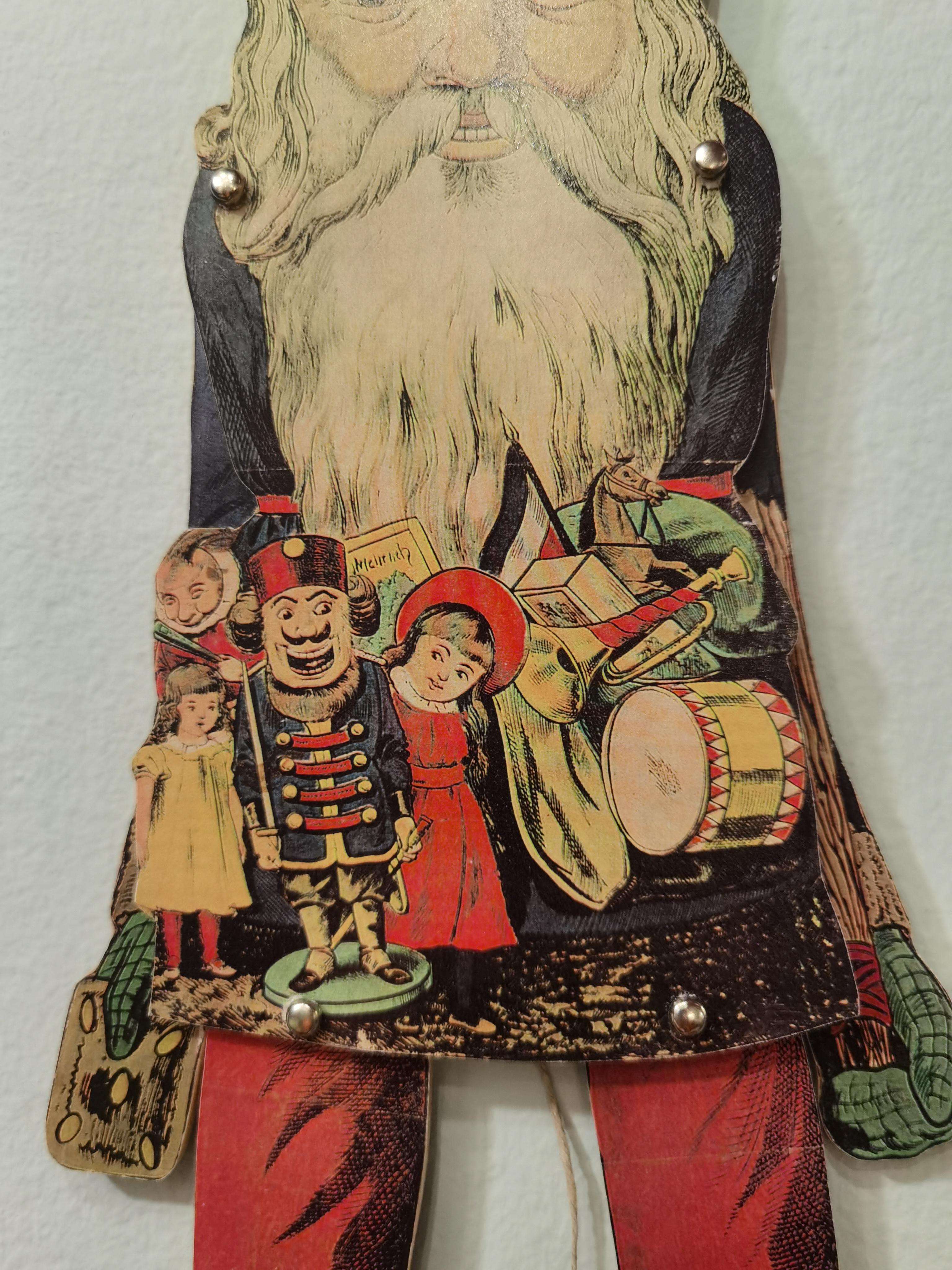 Vintage christmas jumping jack in wood. The front covered in paper with a beautiful vintage decoration Handmade in the area of Erzgebirge Germany. The area of Erzgebirge located in the former eastern part of Germany is very popular for beautiful