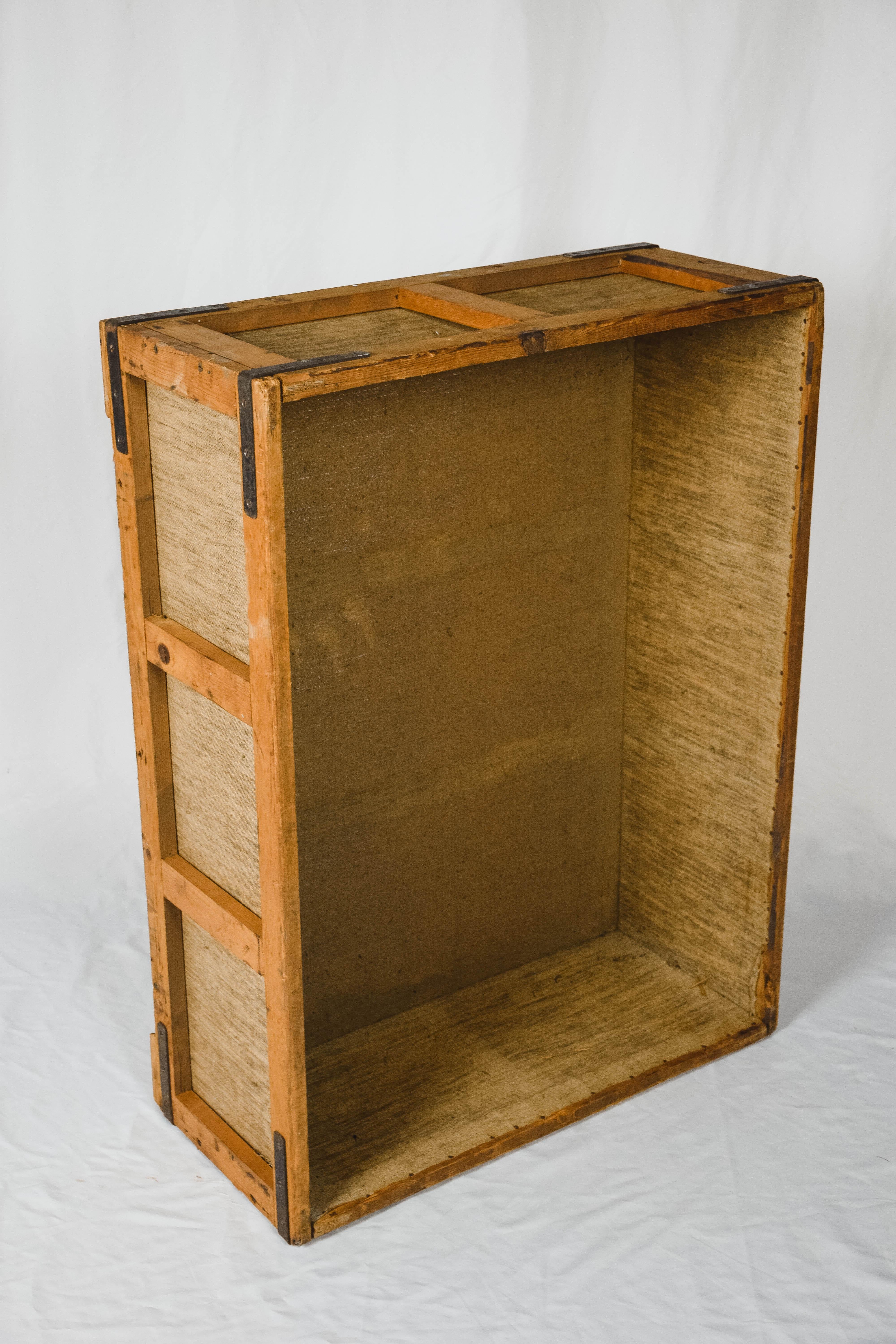 This vintage German cigar bin was used to store cigars which were hand rolled in a German cigar factory. The bin has a beautiful aged wood patina with linen panels. The corners are held together with metal brackets. The bin would look great with any