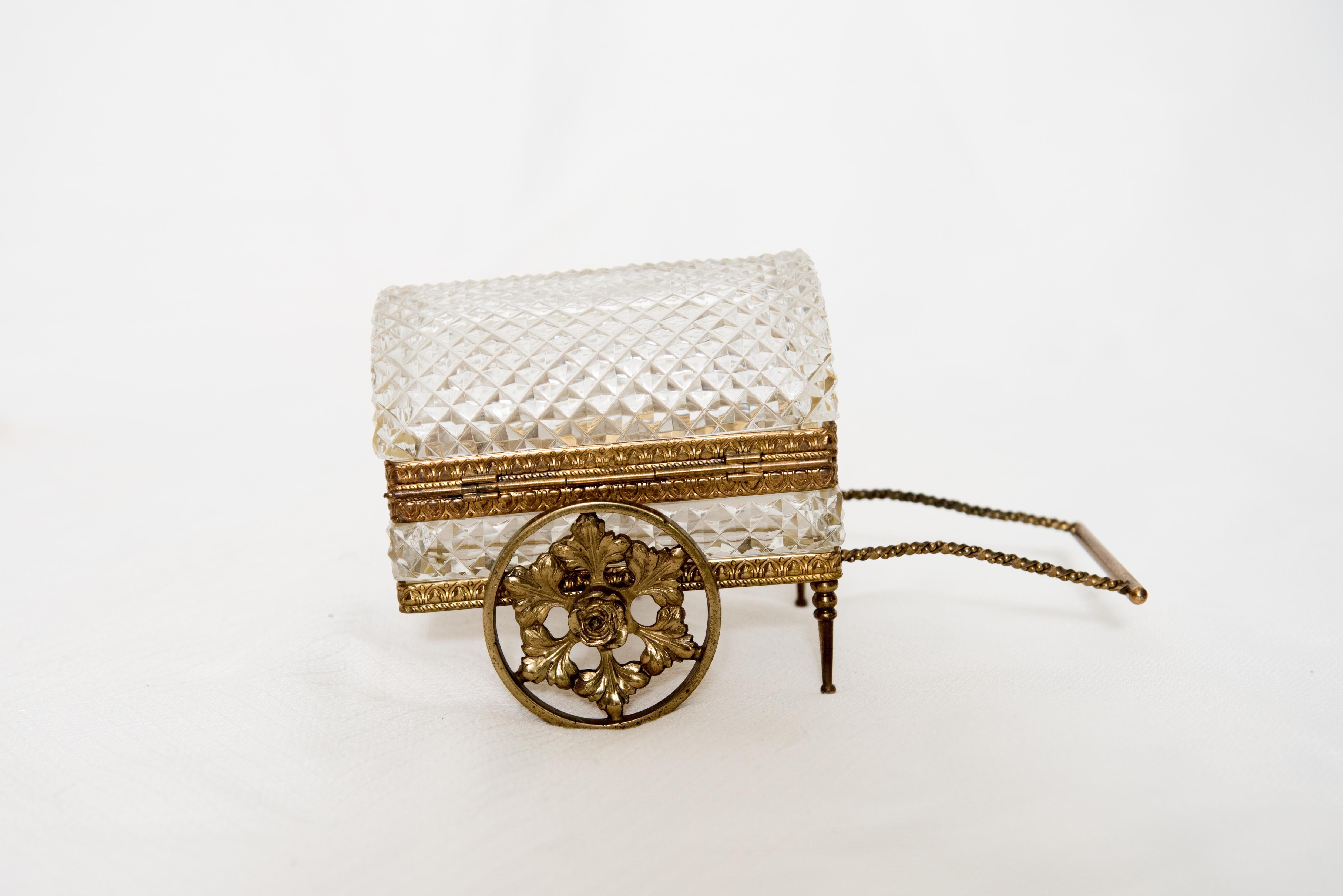 Un très rare coffret/chariot de bijoux en cristal taillé vintage avec des montures en bronze. Le cercueil en cristal bombé est posé sur un socle de bronze à roues tournantes. Une pièce étonnante, d'une taille et d'un poids agréables.

Allemagne de