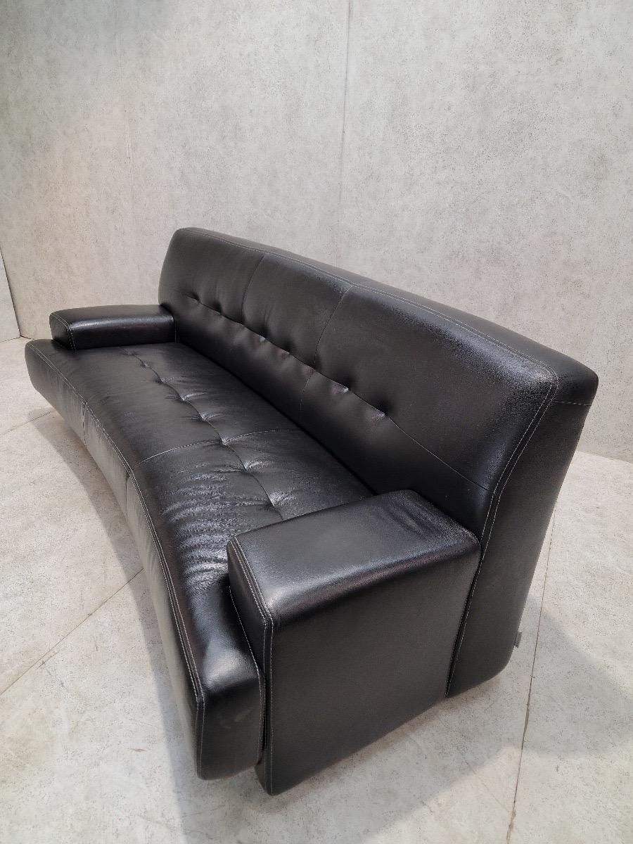 Vintage German Curved Black Leather Mandalay Sofa By W. Schillig

Beautifully designed & hand-crafted full grain curved black leather sofa with wide arms by W. Schillig. This is a piece that adapts perfectly to any living environment. The wood trim