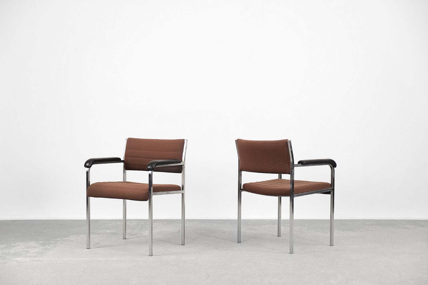 This pair of modernistic armchairs was produced by the German manufactory Fröscher Sitform during the 1970s. The frame is made of solid aluminum. The armchairs are upholstered with thick fabric in an interesting bricky shade of brown. Additionally,