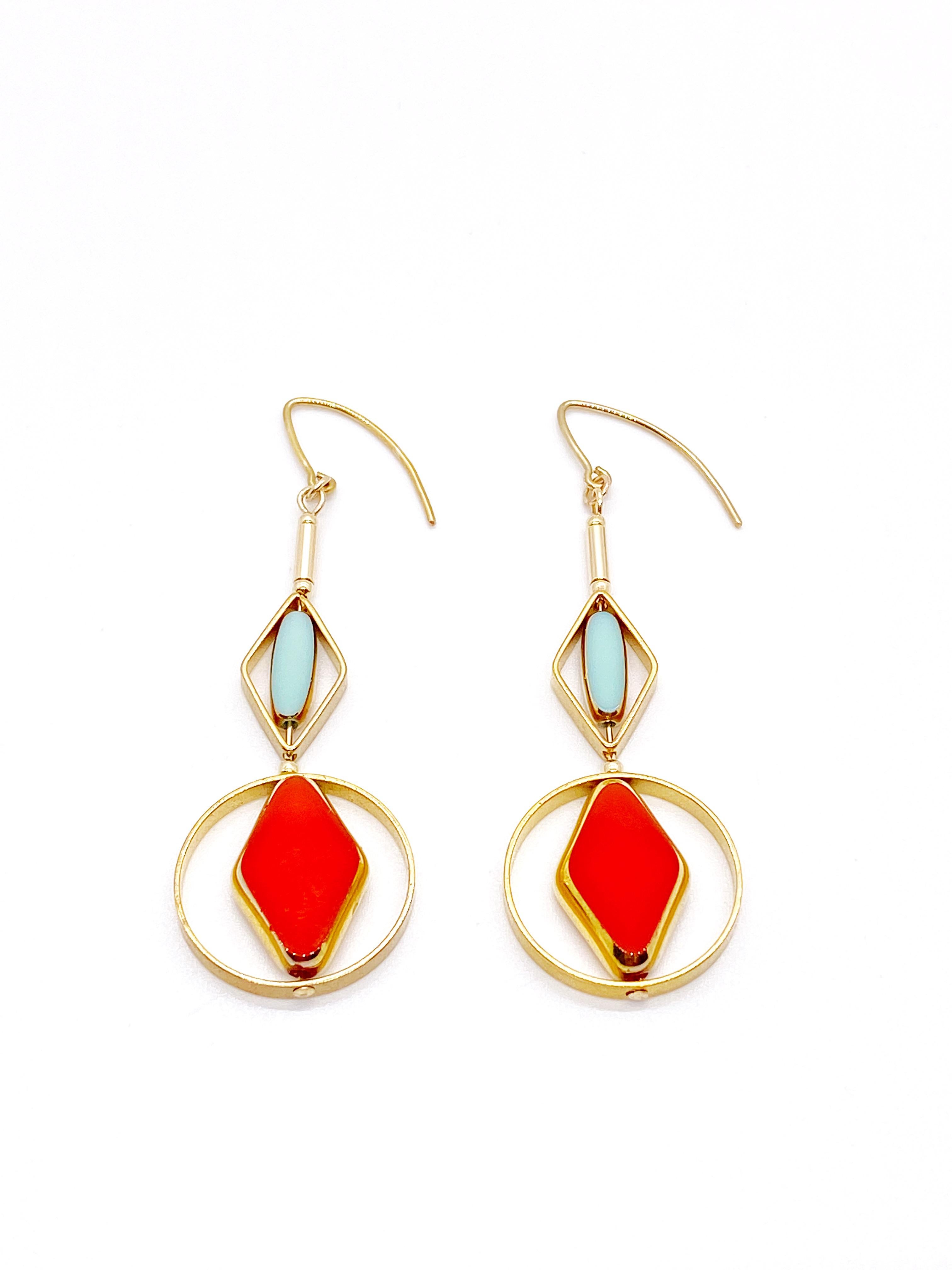 This is for a set of earrings. The earrings consist of orangey red diamond and mini baby blue oblong shaped beads.. They are new old stock vintage German glass beads that are framed with 24K gold. The beads were hand pressed during the 1920s-19760s.