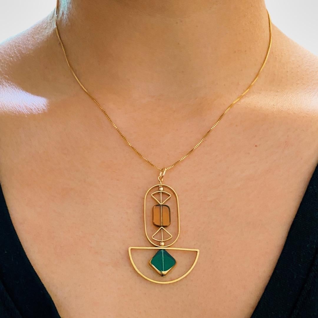 This pendant consist of transparent emerald color diamond and yellow rectangular shaped beads and finished with a 16 inch gold filled chain. 

The beads are new old stock vintage German glass beads that are framed with 24K gold. The beads were hand