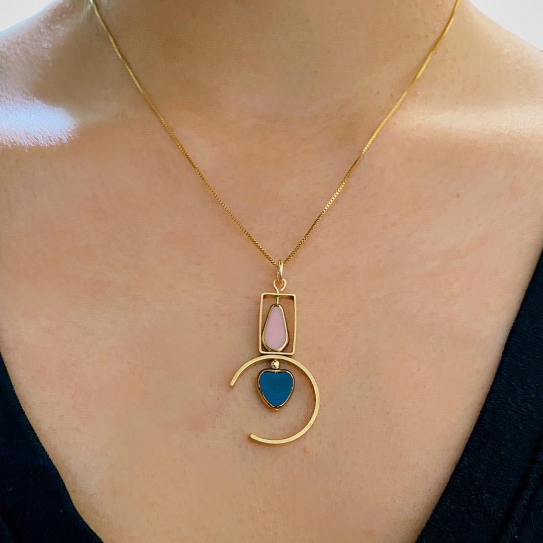 The pendant consist of blue heart and pink elongated pentagon shaped beads and finished with a 16 inch gold filled chain.

The beads are new old stock vintage German glass beads that are framed with 24K gold. The beads were hand pressed during the