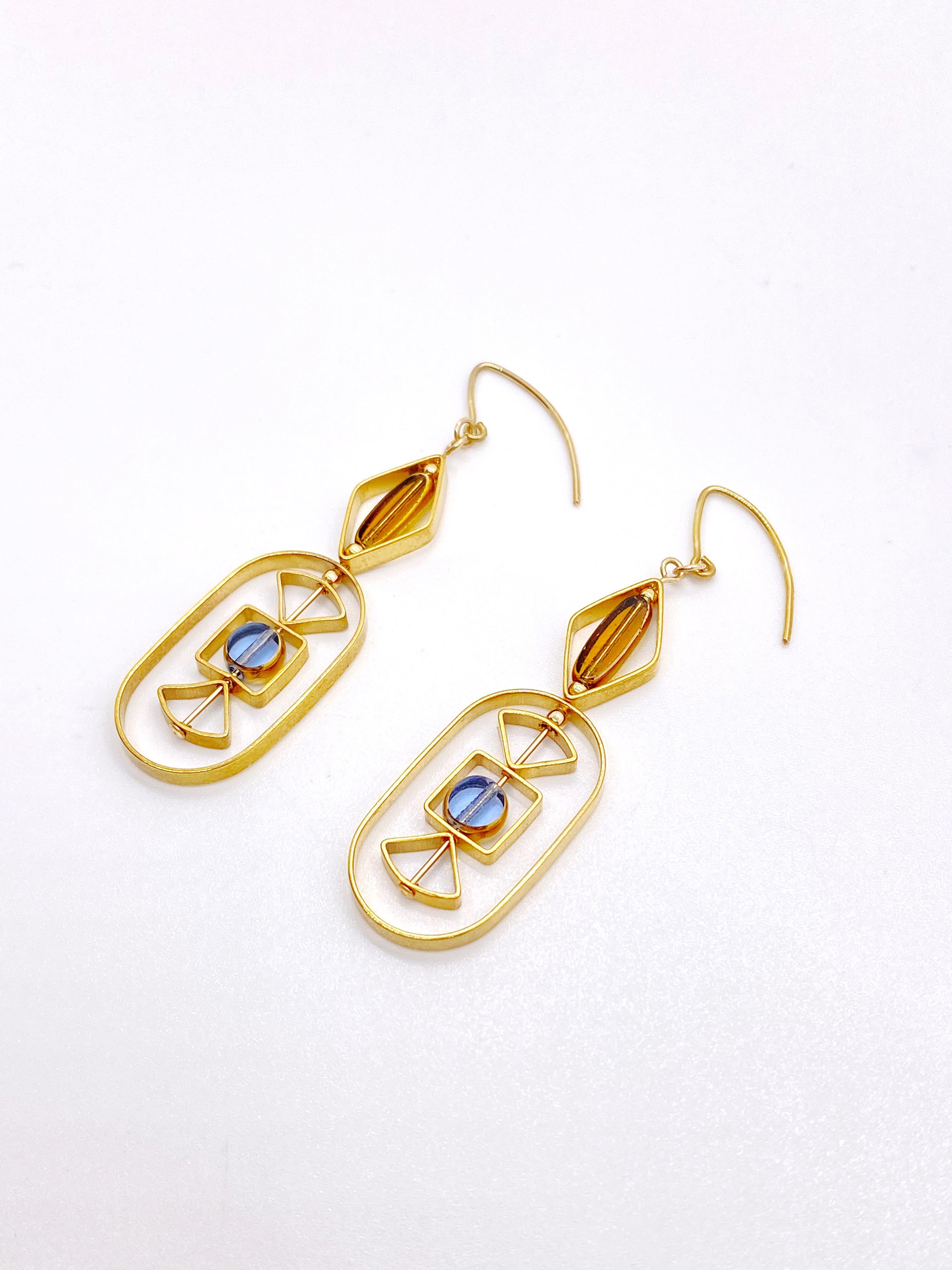This is for a set of earrings. The earrings consist of  1 mini blue circle and 1 mini oblong shaped transparent beads. They are new old stock vintage German glass beads that are framed with 24K gold. The beads were hand pressed during the