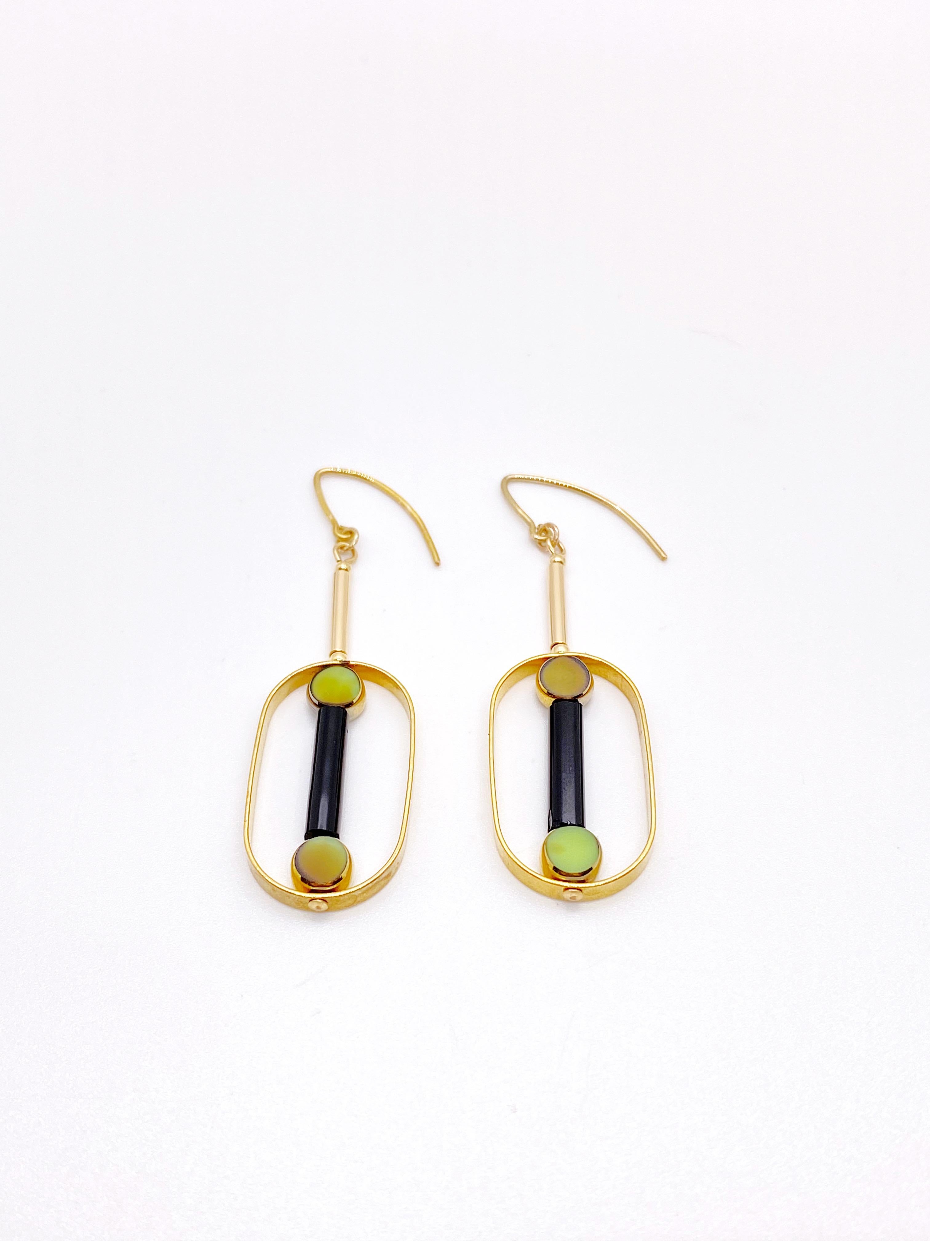 This is for a set of earrings. The earrings consist of 2 mini marbled green circle shaped beads with black glass tube beads. They are new old stock vintage German glass beads that are framed with 24K gold. The beads were hand pressed during the