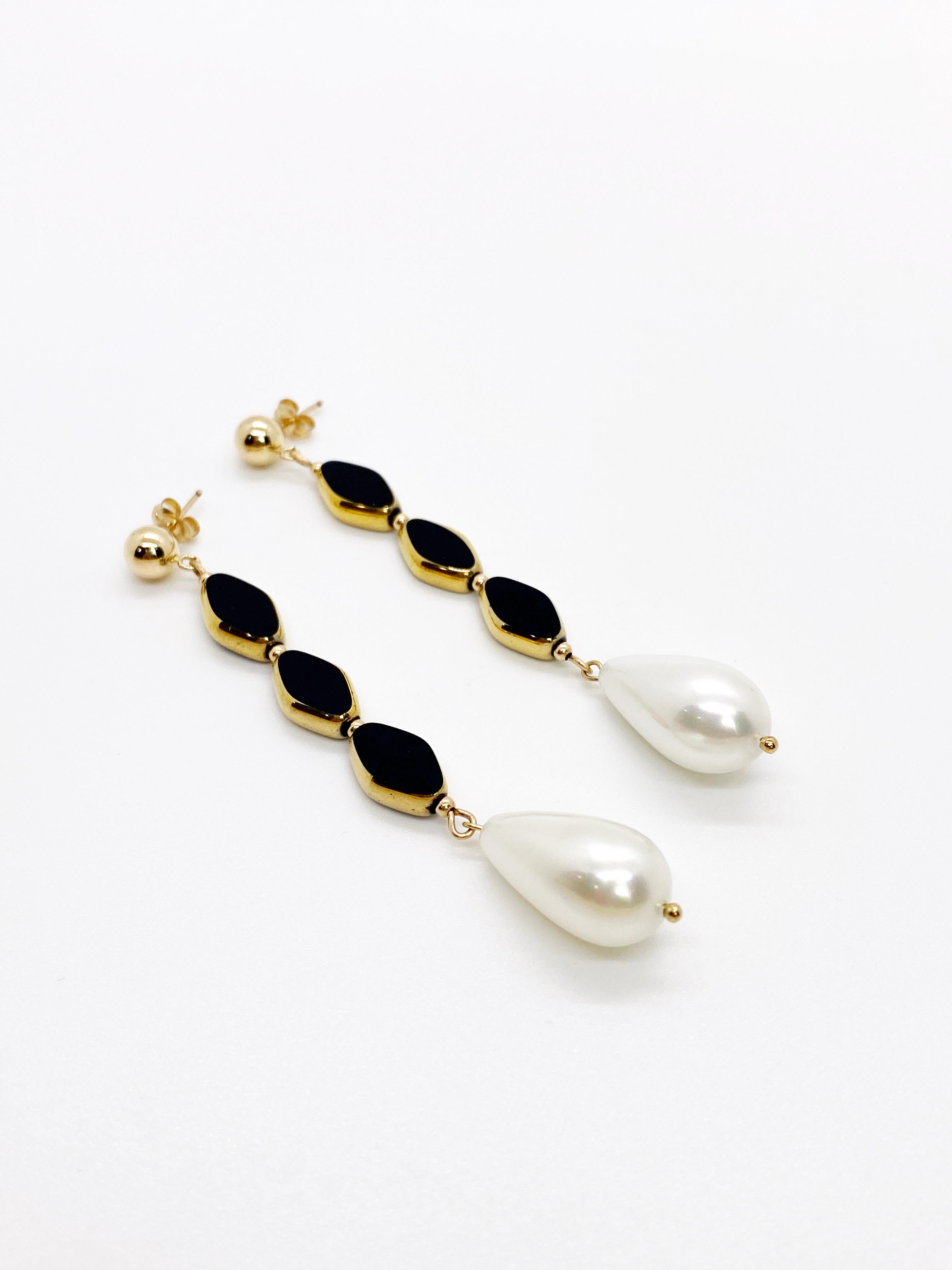 A pair of 3 black opaque colored vintage German glass beads edged with 24K gold and a beautiful south sea pearl dangles at the end. A 14K gold-filled stud to finish the earring.

The 24K gold-edged vintage German glass beads (circa 1920s-1960s) are