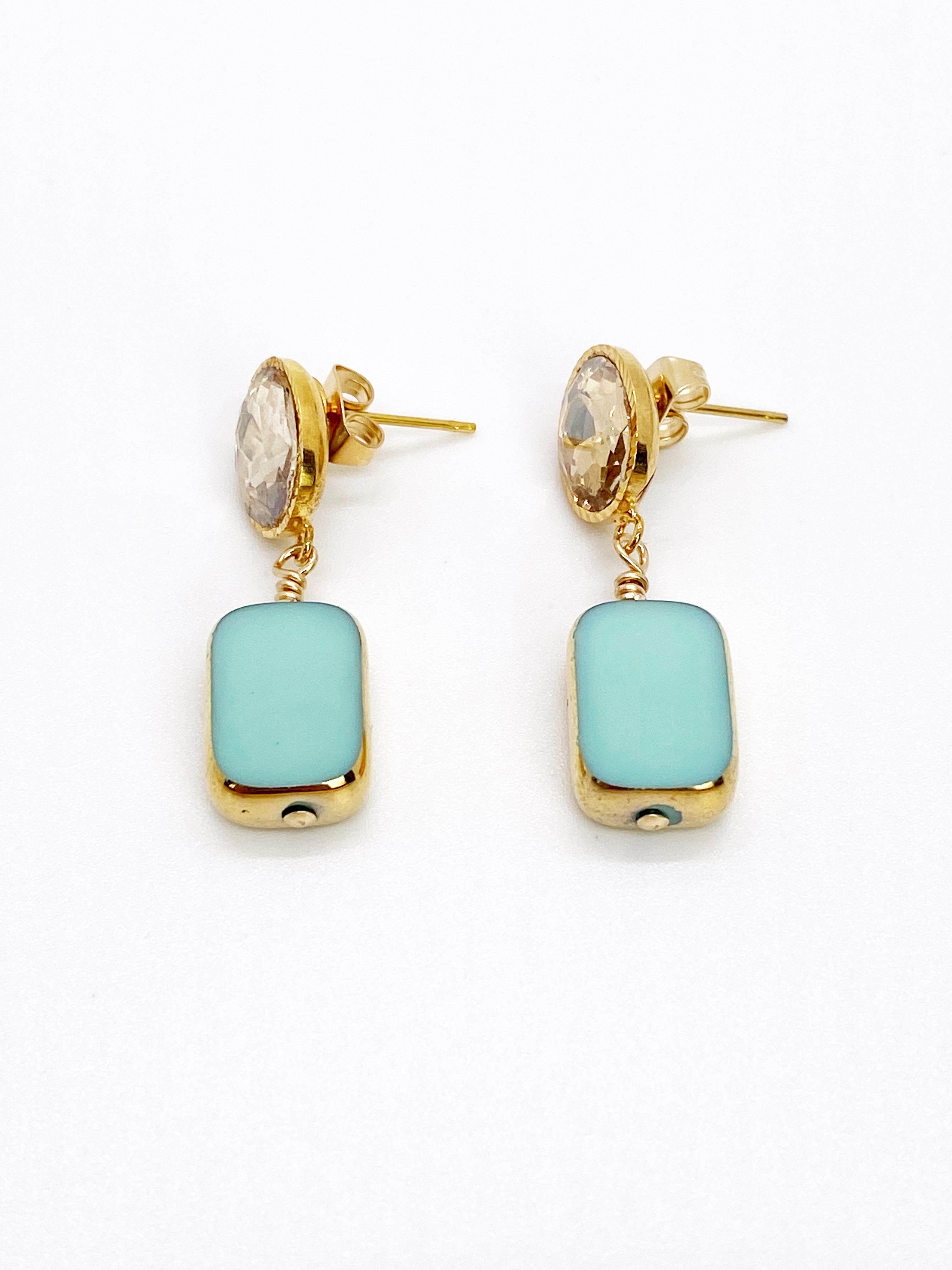 A sea foam green colored German glass beads edged with 24K gold dangles on a 24K gold plated setting with a champagne glass cabochon.

The German vintage glass beads are considered rare and collectible, circa 1920s-1960s.

*Our jewelry have maximum