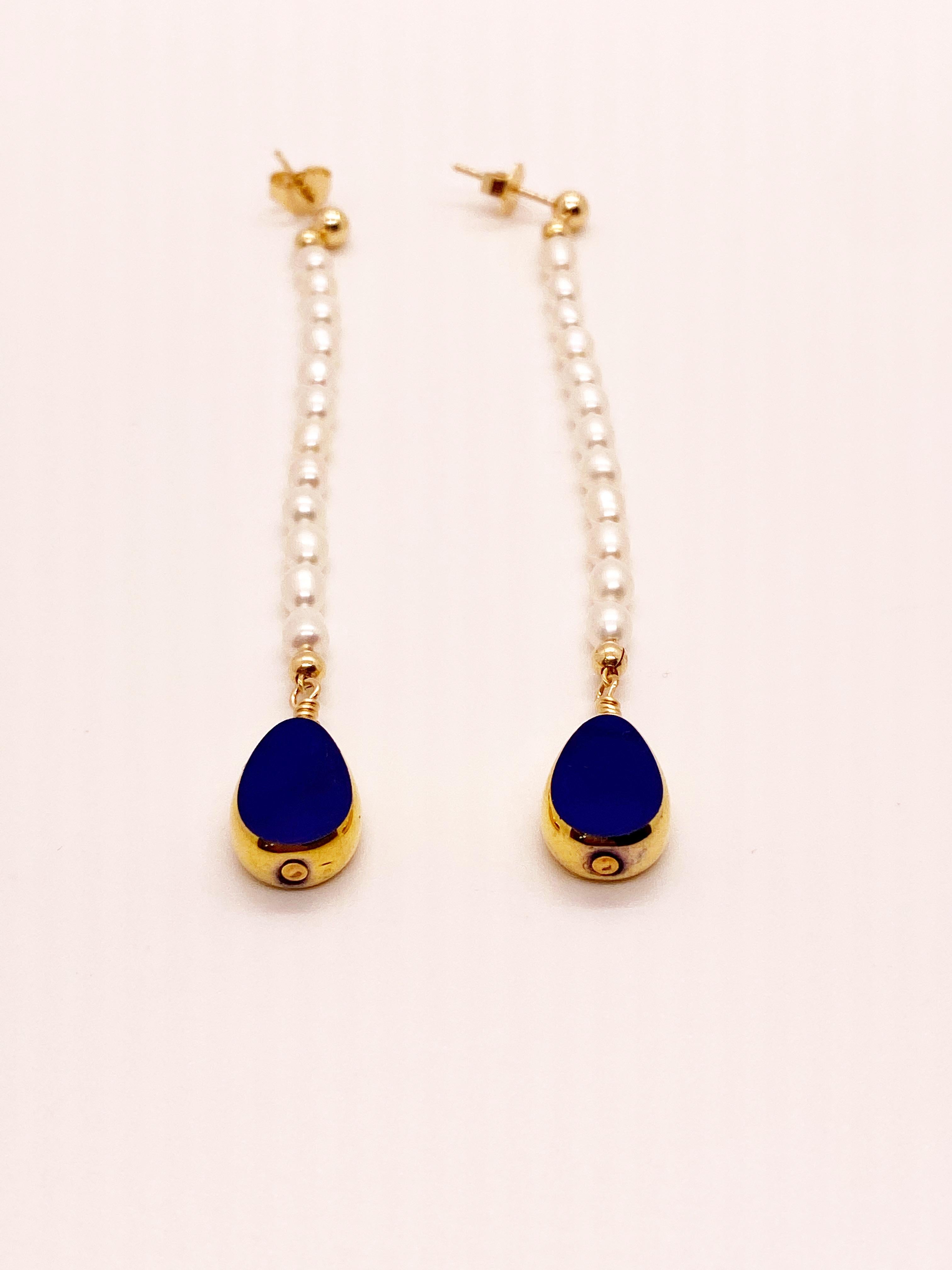Blue opaque teardrop vintage German glass beads edged with 24K gold dangles on freshwater pearls on 14K gold filled earring stud. Entire earring is about 3.5 inches.

The vintage German glass beads are considered rare and collectible, circa