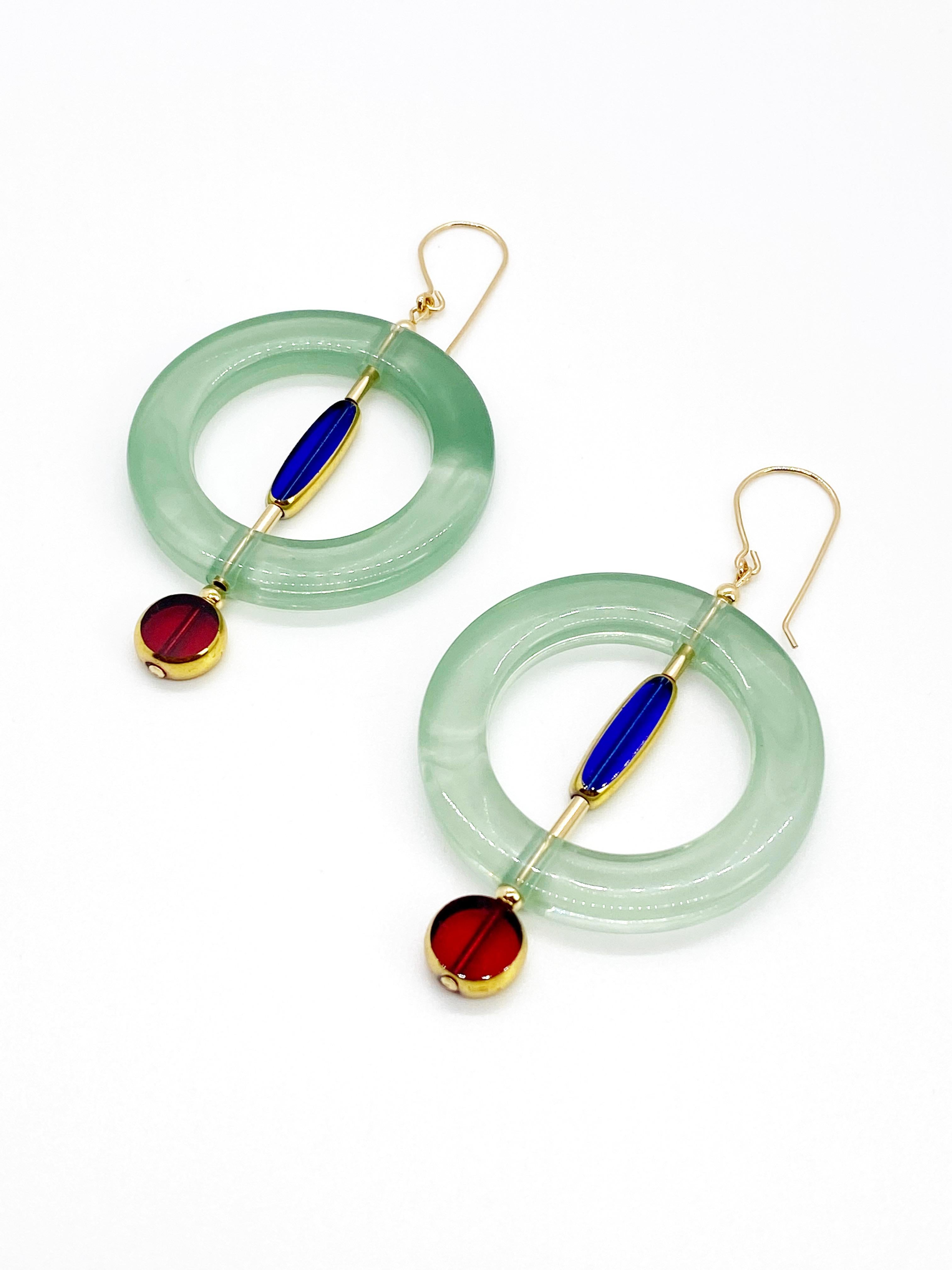 Chaque boucle d'oreille est composée de 2 perles de verre vintage allemand translucides qui sont encadrées d'or 24K avec un anneau de lucite vintage. Elles sont rehaussées de perles rondes et de perles tubulaires remplies d'or. Les boucles