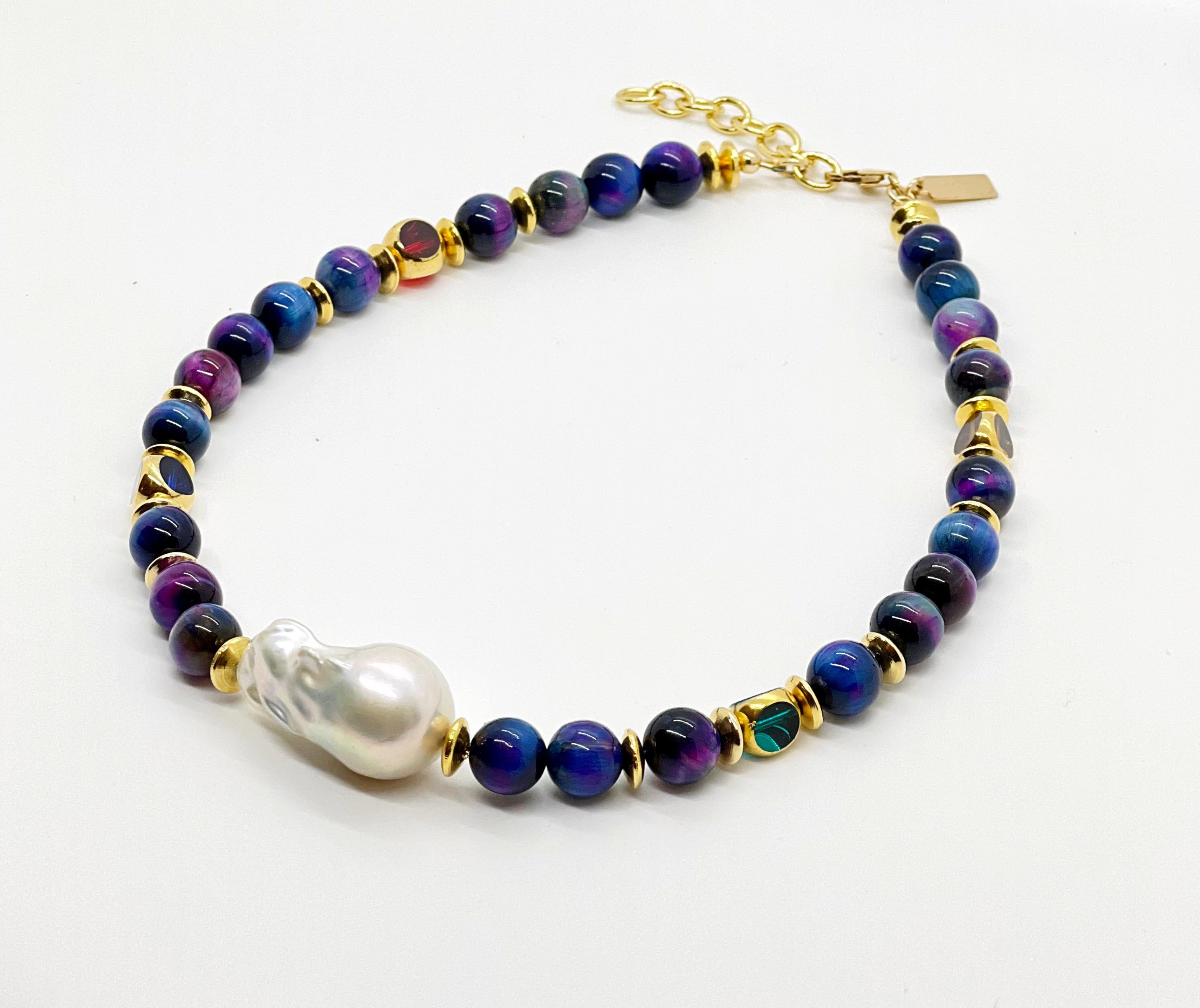 Made of glorious blue tiger eye semi-precious gemstone that reflects colors from purple to blue with hints of golden brown. It is complimented by transparent colorful German vintage glass beads that are edged with 24K gold. On the center is a large