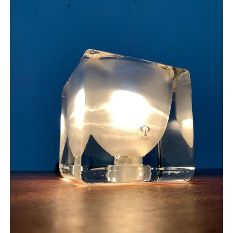 Lámpara de sobremesa cubo de cristal del conocido fabricante Peill & Putzler. Aquí tienes la versión satinada interior.

El cuerpo de la lámpara consiste en una simple jarra de cristal. En su interior, está ahuecado en forma de parábola y alberga