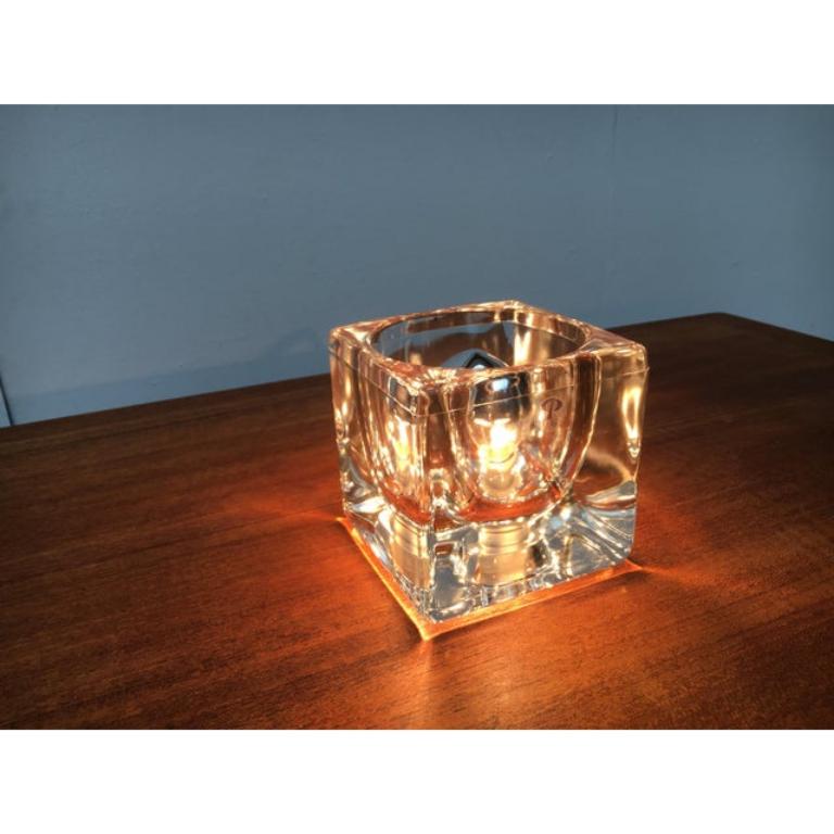 Lámpara de sobremesa cubo de cristal del conocido fabricante Peill & Putzler. Aquí en la versión completamente clara.

El cuerpo de la lámpara consiste en una simple jarra de cristal. En su interior, está ahuecado en forma de parábola y alberga una