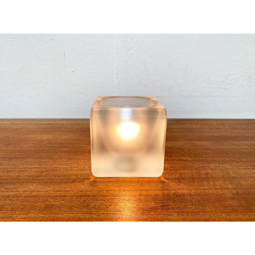 Lámpara de sobremesa cubo de cristal del conocido fabricante Peill & Putzler. Aquí en la versión rara, completamente satinada.

El cuerpo de la luminaria consiste en una simple jarra de cristal. En su interior, está ahuecado como una parábola y