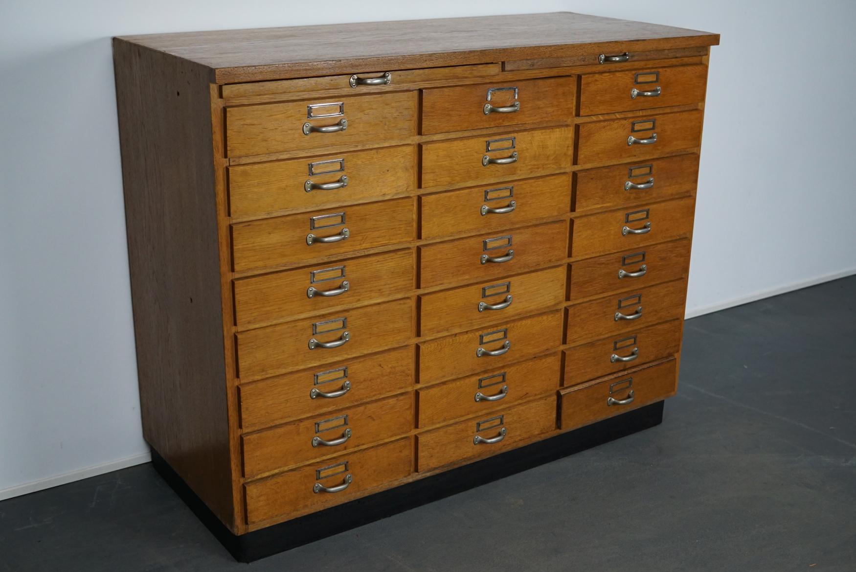 This apothecary cabinet was produced during the 1950s in Germany. This piece features 24 drawers with nice metal handles and card holders. The interior dimensions of the drawers are: D x W x H 45.5 x 33.5 x 7.5 cm.
   