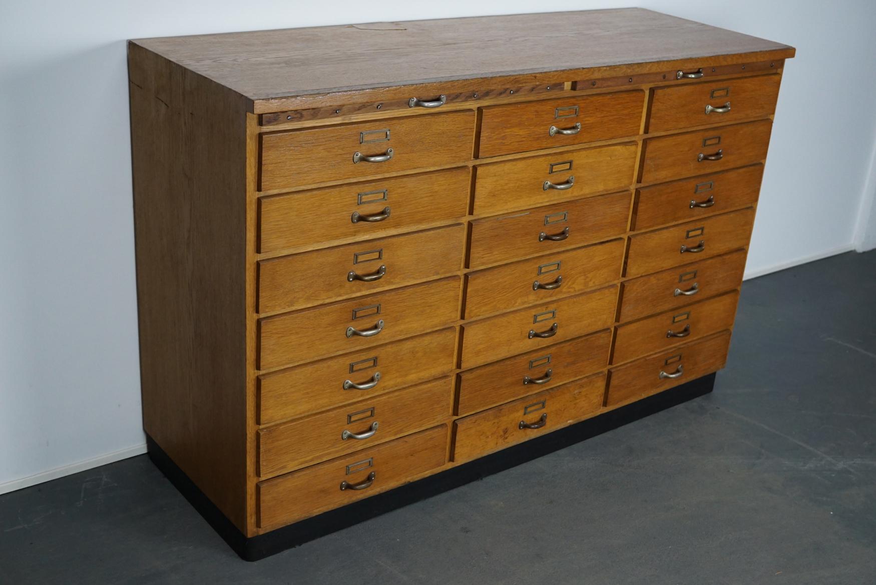 This apothecary cabinet was produced during the 1950s in Germany. This piece features 24 drawers with nice metal handles and card holders. The interior dimensions of the drawers are: D x W x H 45.5 x 43 x 7.5 cm.
