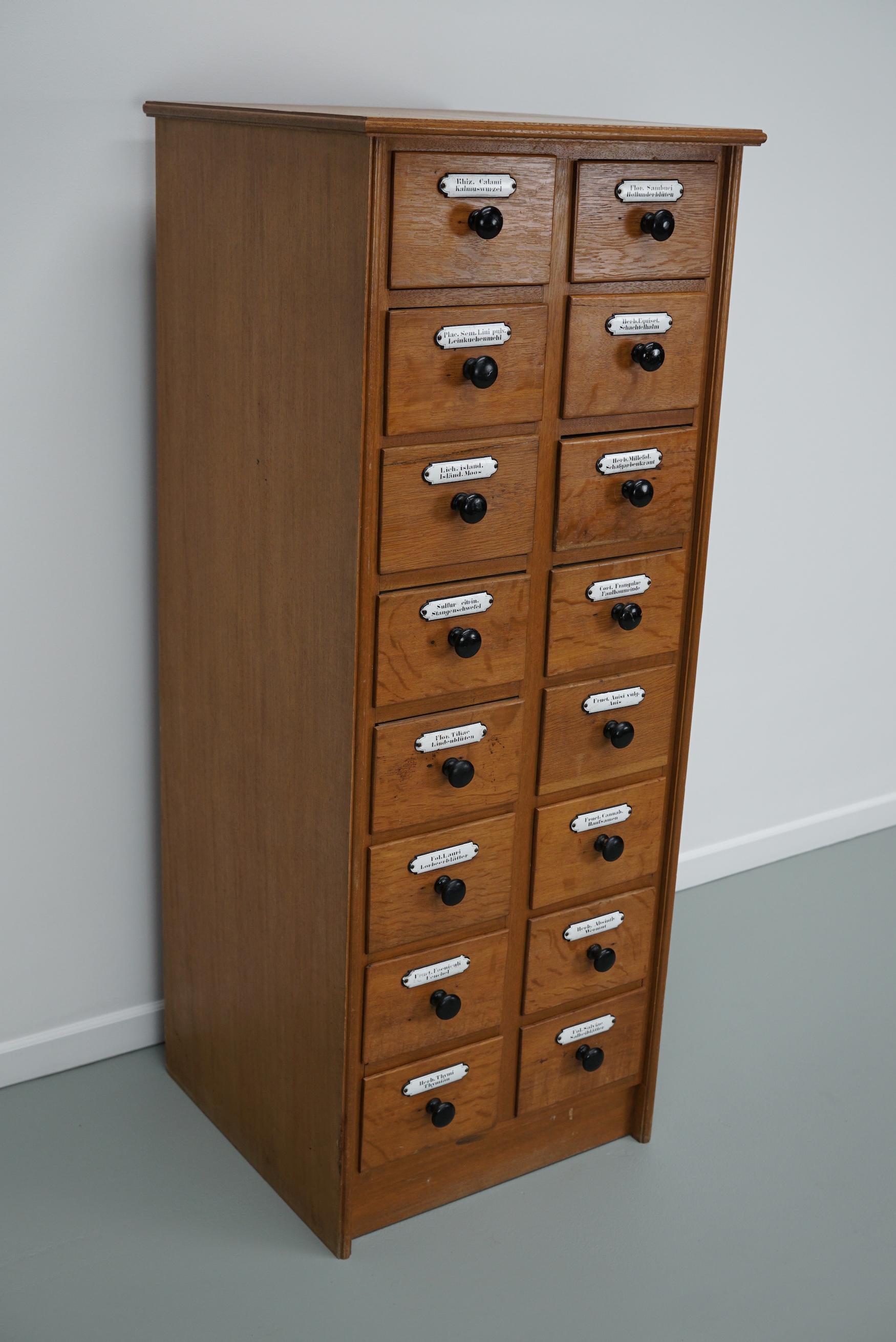 Questa cassettiera da farmacia è stata progettata e realizzata nel 1940 circa in Germania. È realizzato in quercia e impiallacciatura di quercia con pomelli neri e targhette smaltate per il contenuto. Le dimensioni interne dei cassetti sono: DWH 