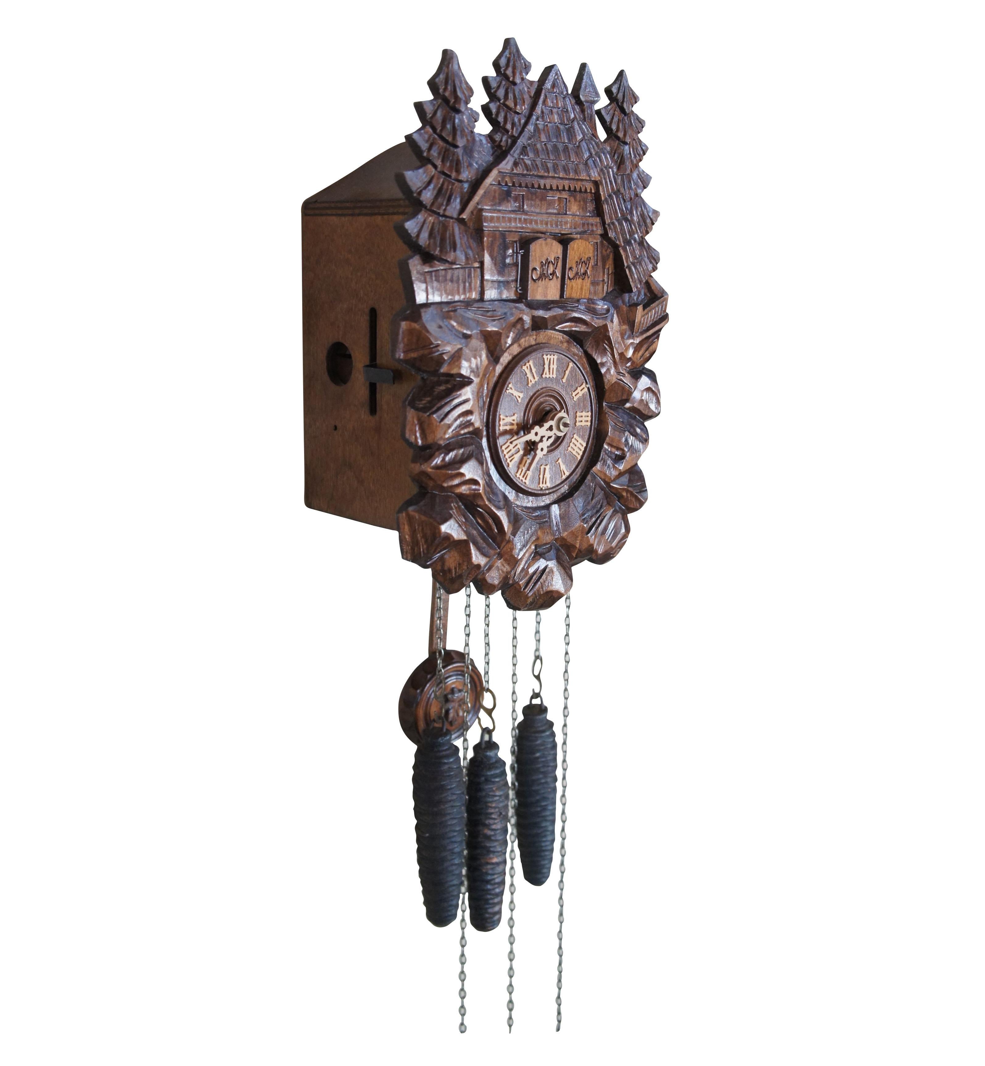 Vintage Schwarzwälder Kuckucksuhr mit deutschem Werk und Schweizer Glockenspiel Der Frohliche Wanderer Edelweiss R Rodgers 2708. Mit geschnitztem Haus mit Bäumen an der Spitze, römischen Ziffern, Pinienzapfengewichten und rundem Abschluss mit Blatt.