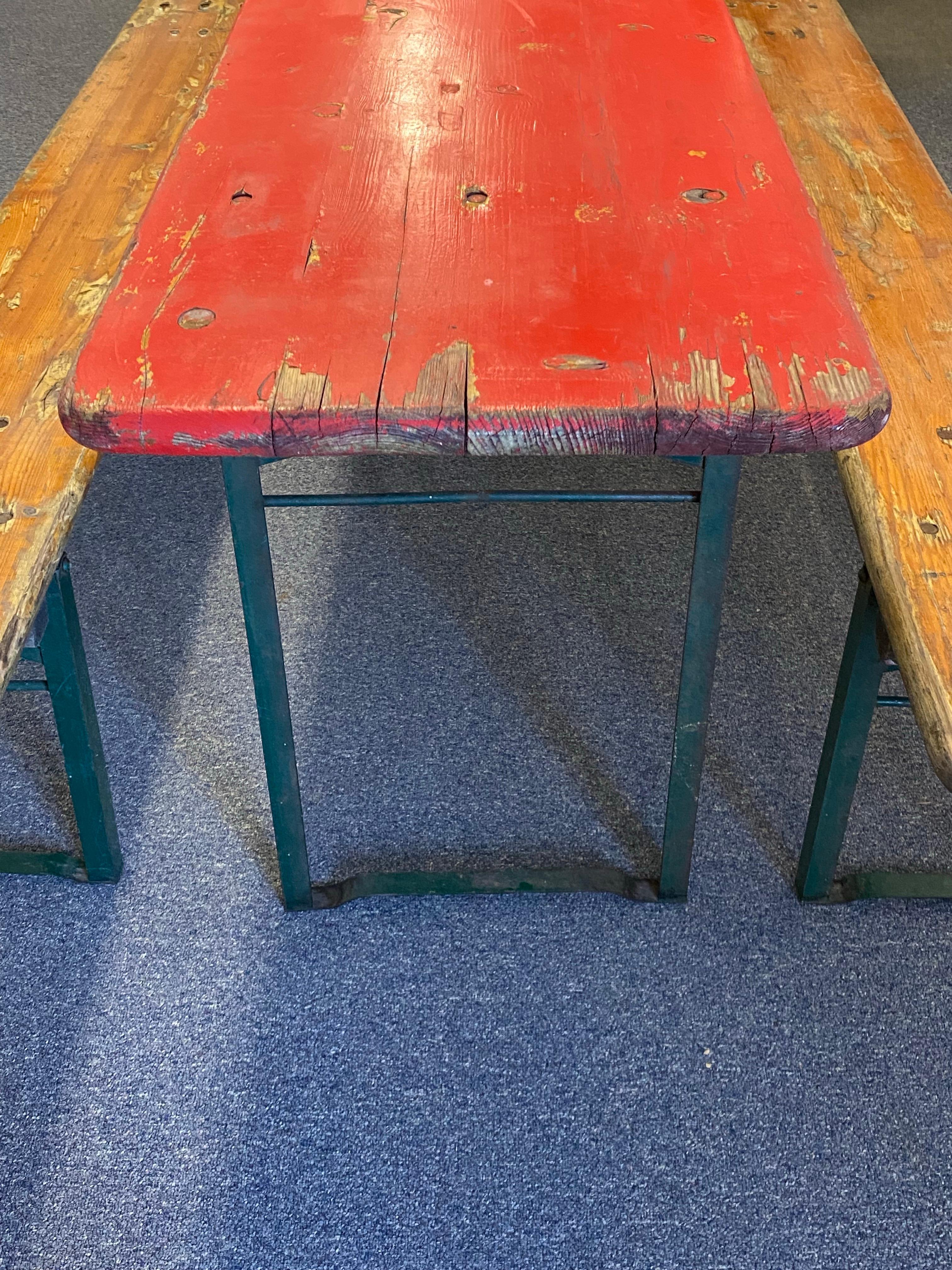 Set di tavoli e panche da birra dell'Oktoberfest tedesco vintage 
Tavolo rosso vintage 
Tavolo pieghevole in legno per birreria tedesca con due panche pieghevoli in legno. Superfici in legno robuste e ben realizzate e gambe pieghevoli in metallo. Il
