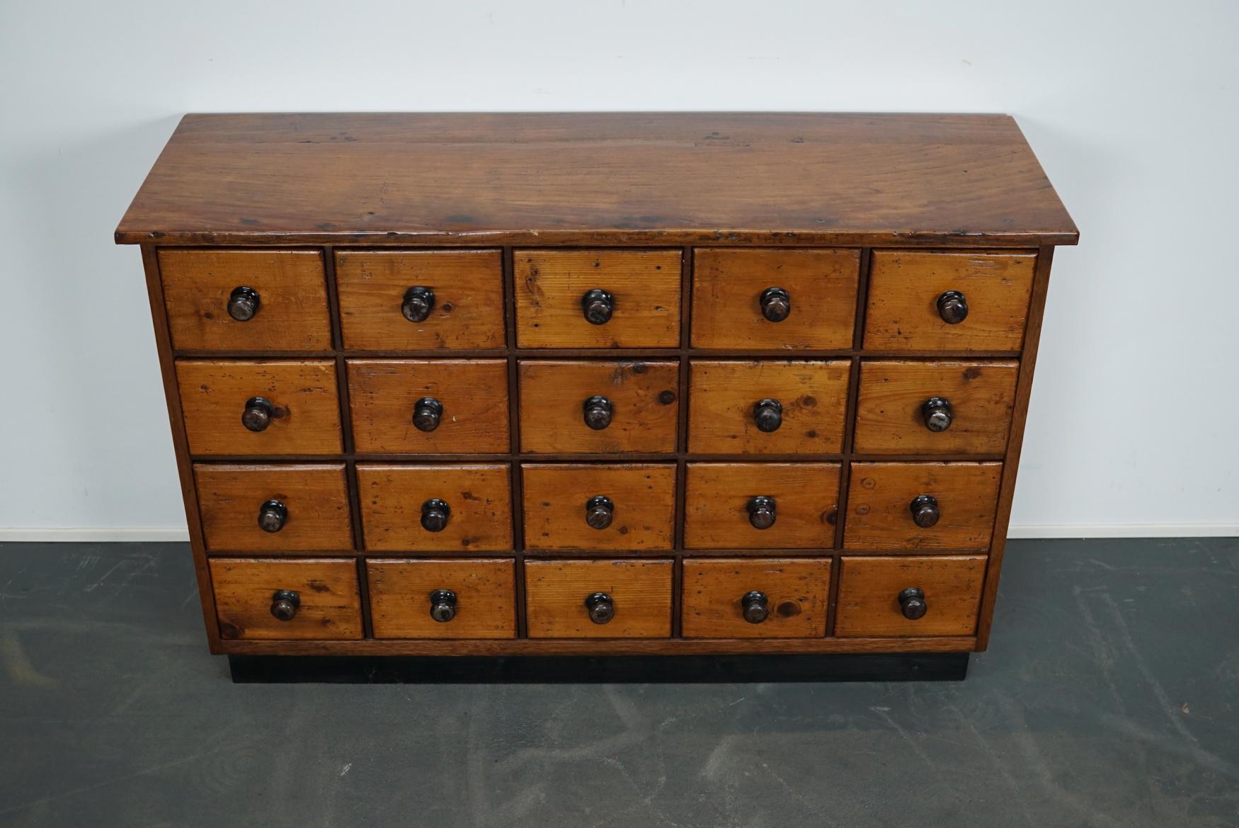 This apothecary cabinet was produced during the 1930s in Germany. This piece features 20 drawers. The interior dimensions of the drawers are: D x W x H 30 x 17.5 x 12 cm.