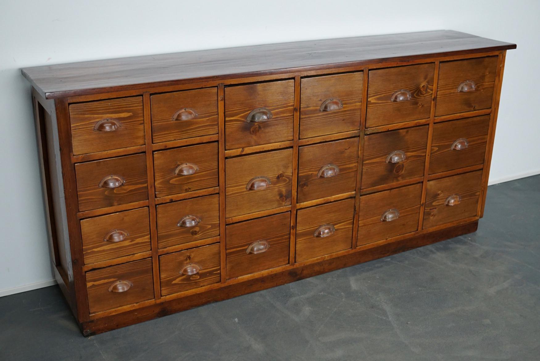 This apothecary cabinet was produced during the 1930s in Germany. This piece features 20 drawers. The interior dimensions of the drawers are: D x W x H 28 x 18.5 x 13.5 and 28 x 22 x 19 cm.