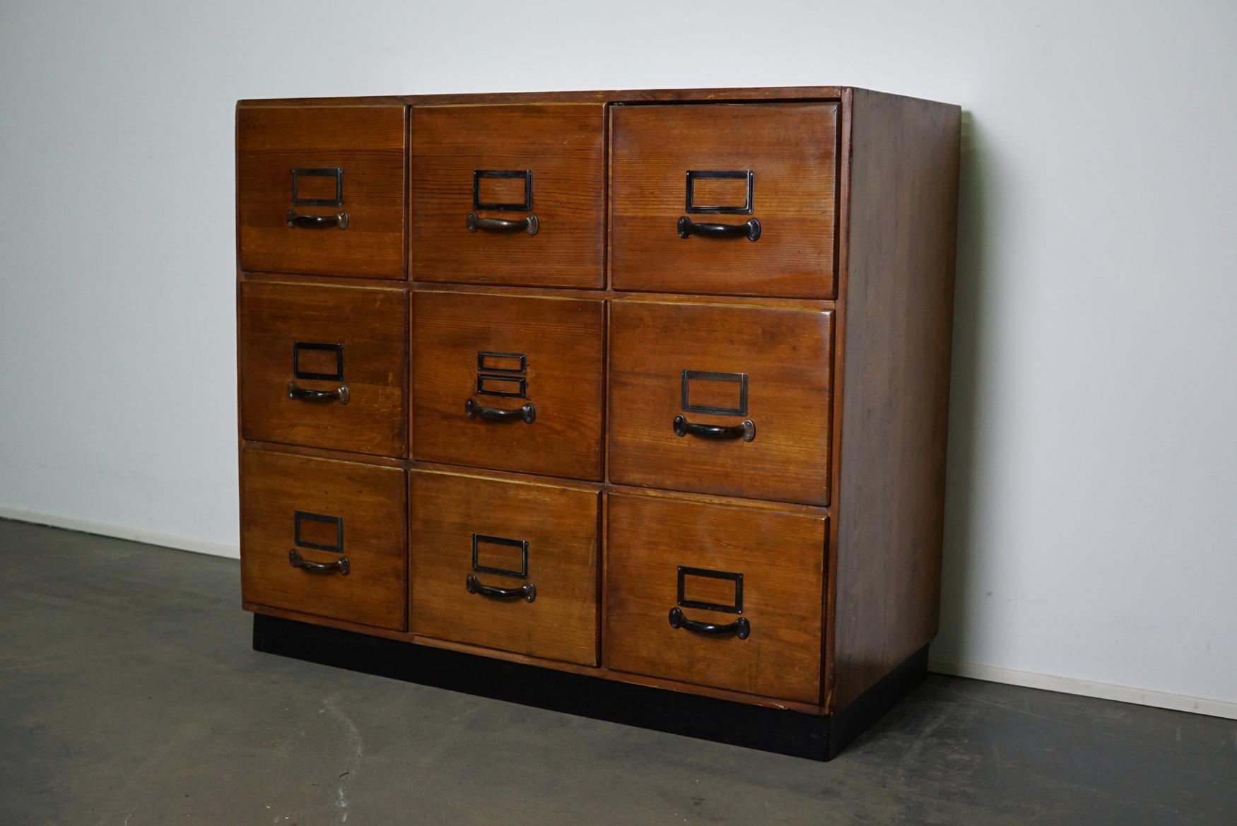 This apothecary cabinet was produced during the 1950s in Germany. This piece features 9 large drawers with nice metal handles and name card holders. The interior dimensions of the drawers are: D x W x H 41 x 28 x 23 cm.