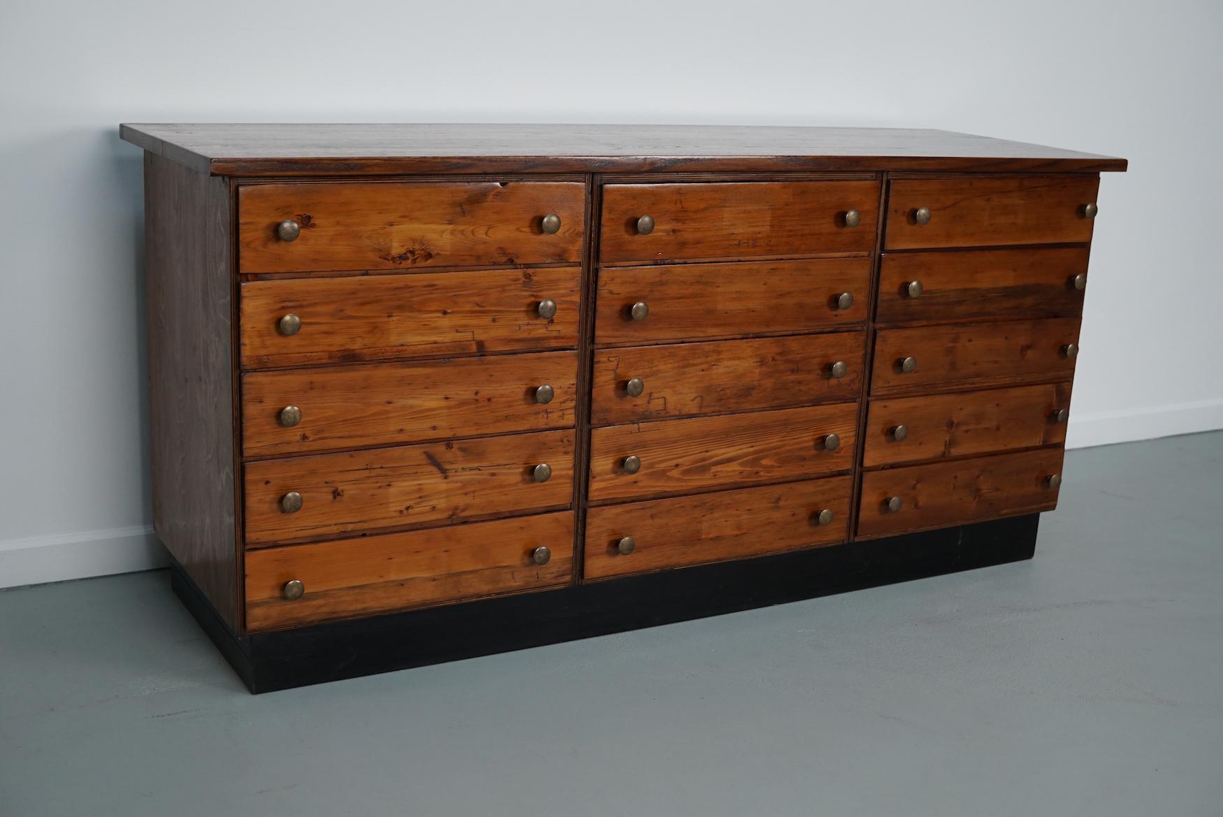 Dieser Apothekerschrank wurde in den 1950er Jahren in Deutschland hergestellt. Dieses Stück hat 15 Schubladen mit schönen Messingknöpfen. Die Innenmaße der Schubladen sind: D x B x H 43 x 40 x 9 cm. Es befindet sich in einem gut restaurierten