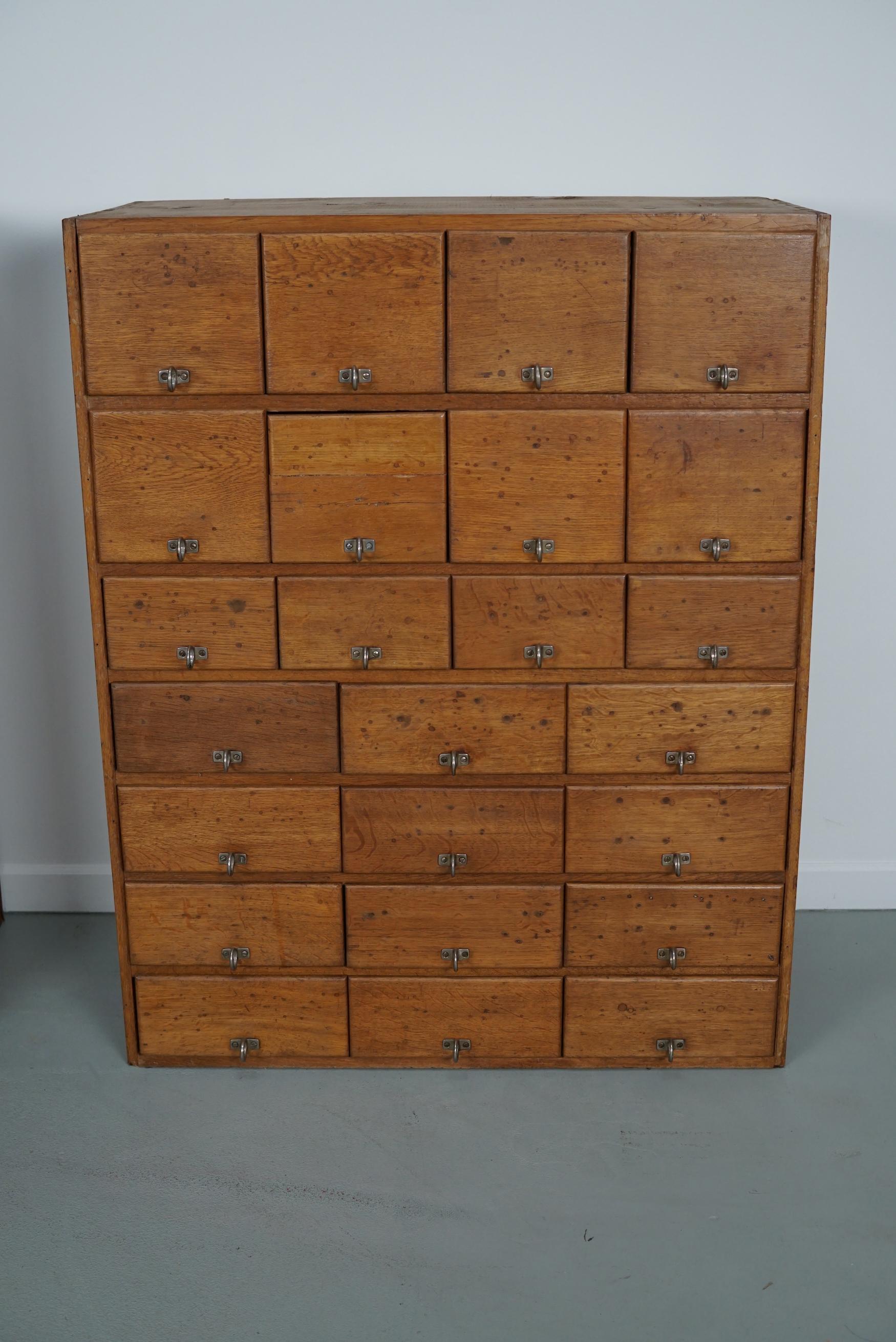 This apothecary cabinet was made circa 1930s in Germany and was later used in a hardware store in Belgium until recently. It features many drawers in different sizes with metal handles.