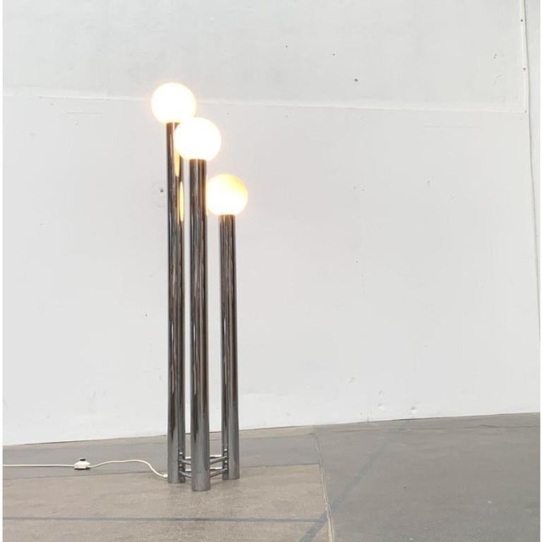 Rare lampadaire de la NO AGE en chrome et verre. Une forme simple mais impressionnante. La lampe est composée de cylindres chromés de différentes hauteurs, reliés entre eux par des toiles en forme de triangle. Au sommet de chacun d'eux se trouve un